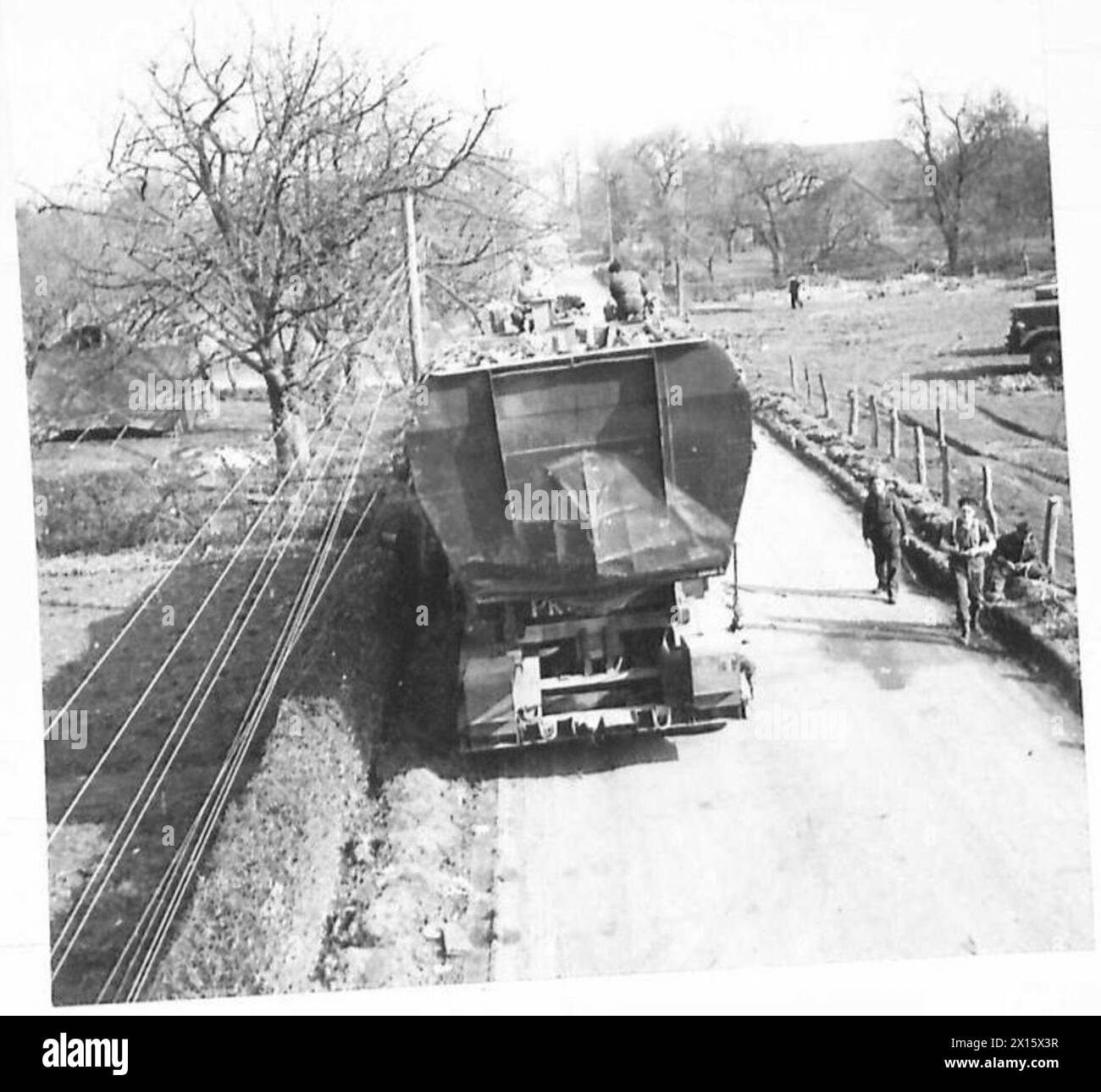 I mezzi della G.V. e un trasportatore si muovono lungo una strada durante i preparativi per le operazioni della forza U dell'esercito britannico, 21st Army Group. Foto Stock