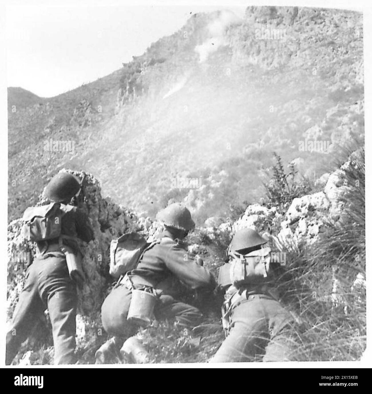 Le truppe della compagnia C della Quinta Armata si spostano attraverso il terreno roccioso vicino al castello di Monastery Hill sotto fumo e fuoco di mortaio durante gli esercizi di ricostruzione della battaglia. Foto Stock