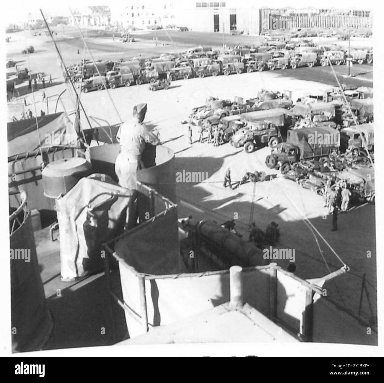 I veicoli militari sono collocati presso i moli in attesa di essere caricati sui carri armati per navi da sbarco (LST) durante i preparativi per l'invasione in Nord Africa. Foto Stock