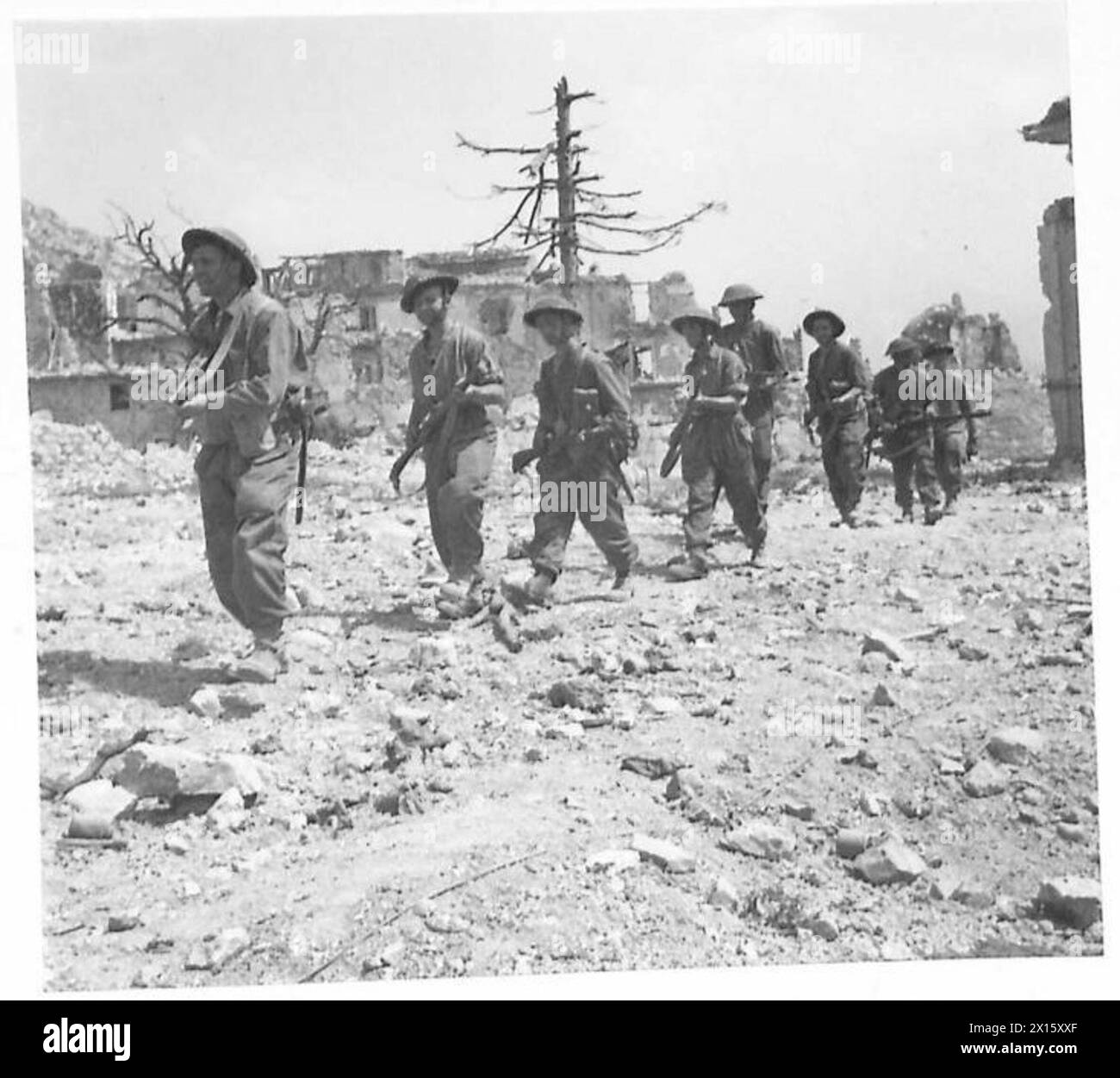 Gli uomini del reggimento East Surrey marciano verso Cassino per completare le operazioni di rapping-up contro le rimanenti forze tedesche durante la campagna italiana. Foto Stock