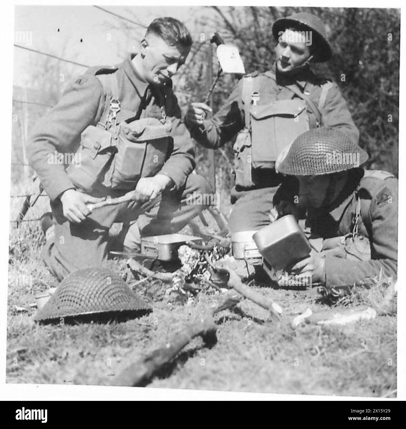 Un piccolo gruppo di un battaglione del personale del Nord prepara la colazione su un fuoco a legna alla luce del sole del mattino presto durante le operazioni sul campo sotto la supervisione dell'esercito britannico. Foto Stock