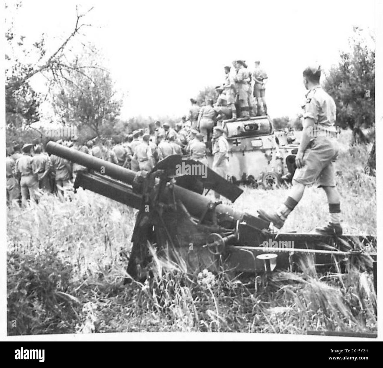 I soldati si radunano intorno a un carro armato distrutto da 25 libbre, rendendo omaggio ai compagni caduti durante un'osservazione e un briefing sul campo di battaglia. Foto Stock