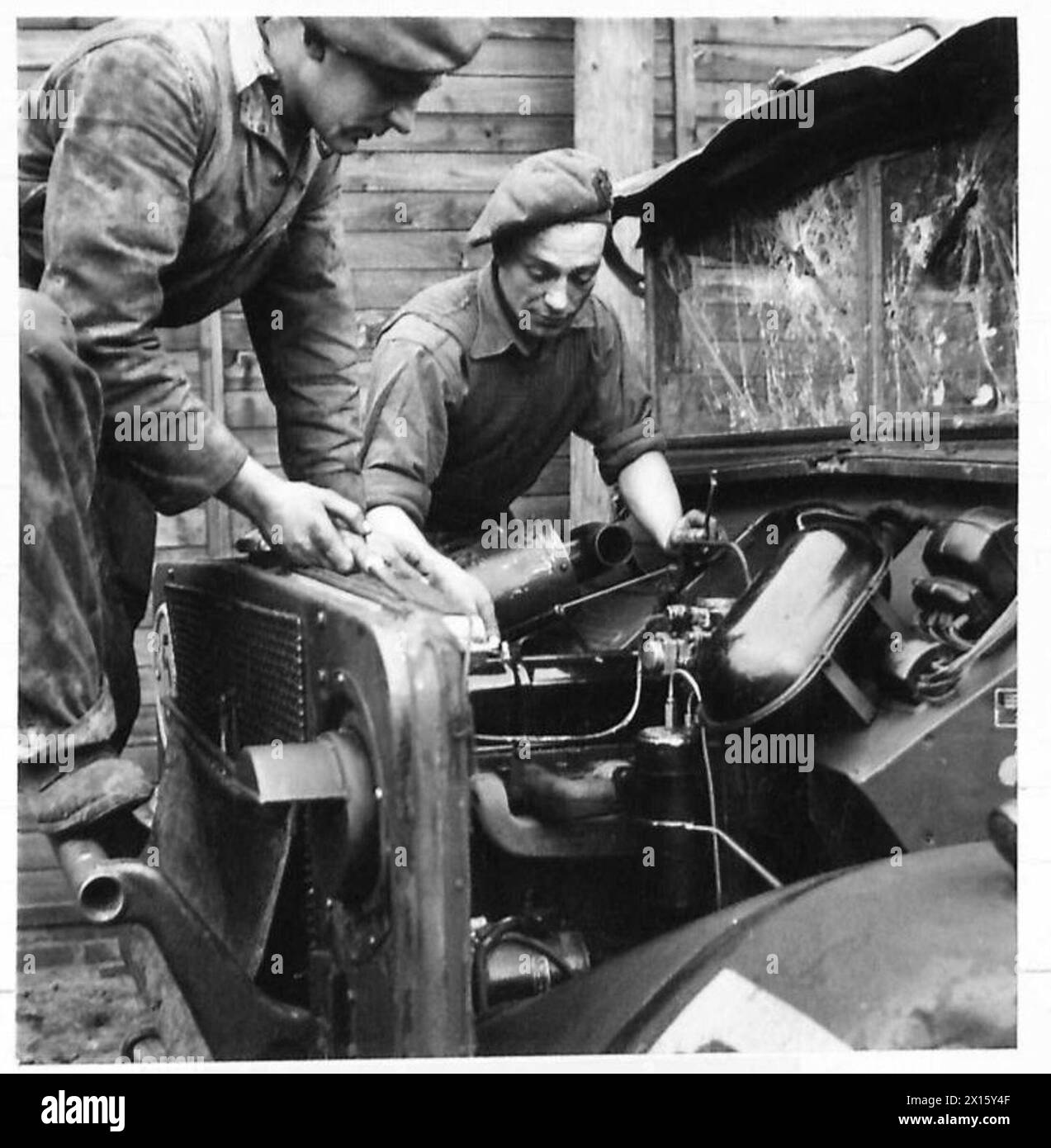 Private Hill e il sergente Brennan, montatori M.T., sintonizzano e mantengono un motore da pista al campo di riposo K.S.L.T., British Army, 21st Army Group. Foto Stock