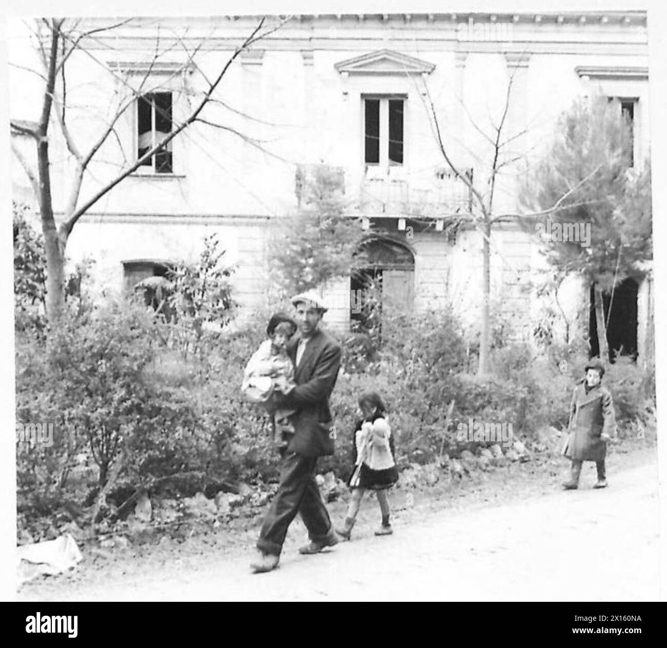 Un rifugiato italiano e le sue due figlie tornano a casa loro durante le operazioni dell'esercito britannico, illustrando il movimento civile nelle aree post-belliche. Foto Stock