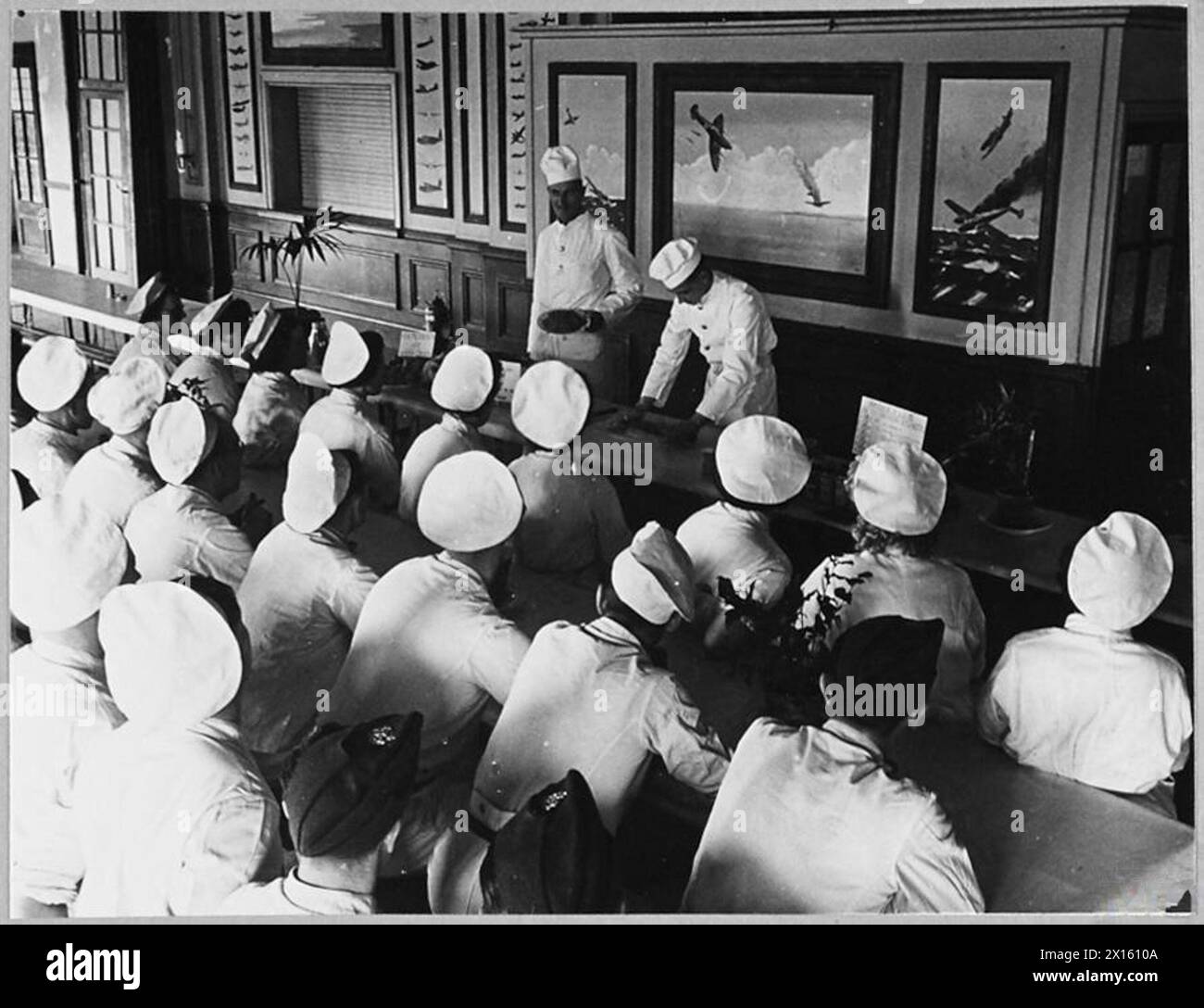 I CUOCHI DI R.A.F. E W.A.A.F. STUDIANO LA CUCINA migliore DEL TEMPO DI GUERRA - (foto pubblicata nel 1942) i cuochi di R.A.F. e W.A.A.F. presso la cucina sperimentale del Ministero dell'aria, studiano i modi migliori per trasformare il cibo in tempo di guerra in pasti nutrienti e appetitosi per gli aviatori. Cuoce in una stazione R.A.F. imparando un nuovo piatto che fa andare la carne oltre la Royal Air Force Foto Stock