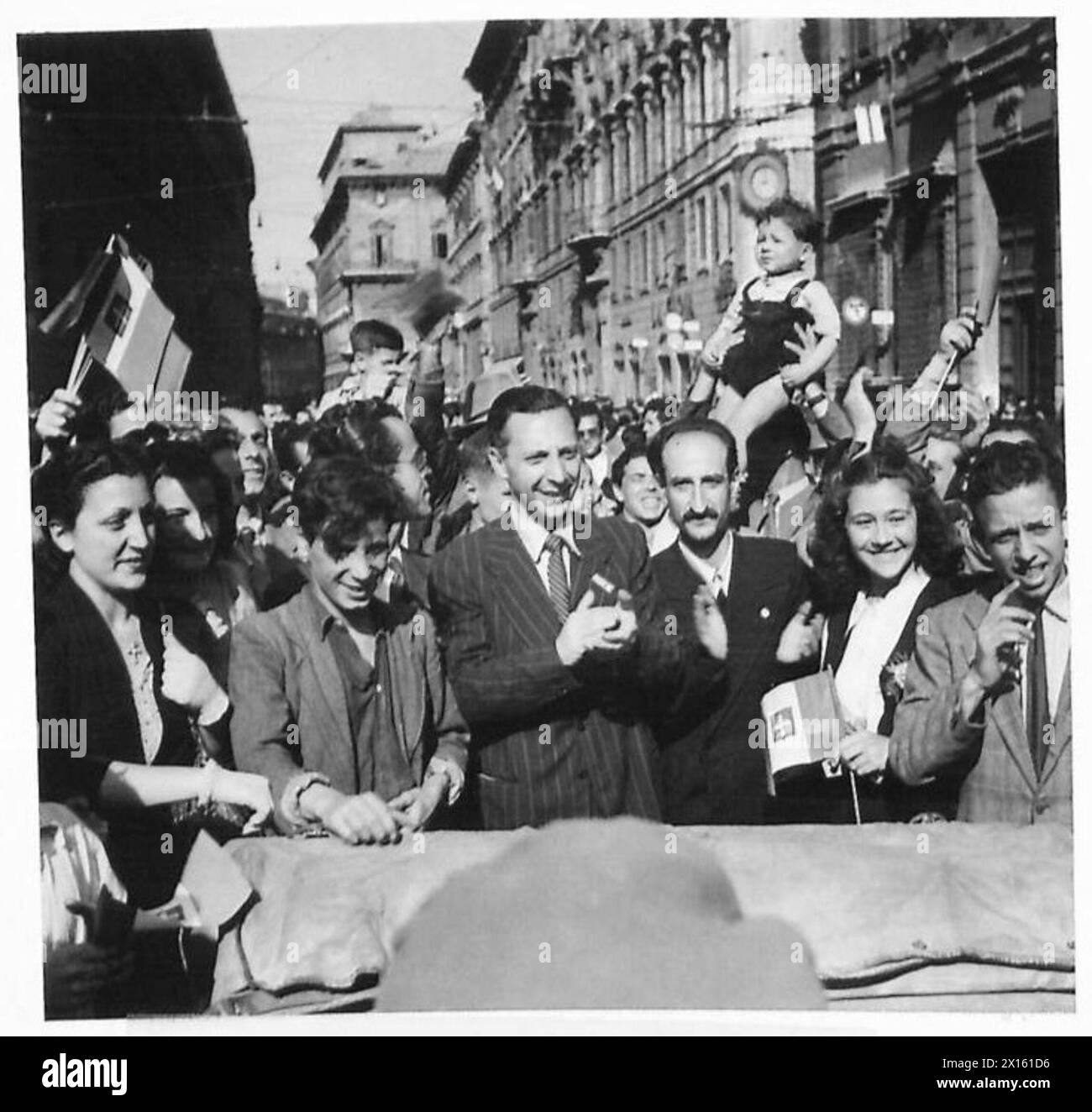 I residenti della città esprimono un'intensa gioia nelle scene pubbliche mentre le forze dell'esercito britannico occupano aree urbane in Nord Africa, Sicilia, Italia, Balcani e Austria tra il 1942 e il 1946. Foto Stock