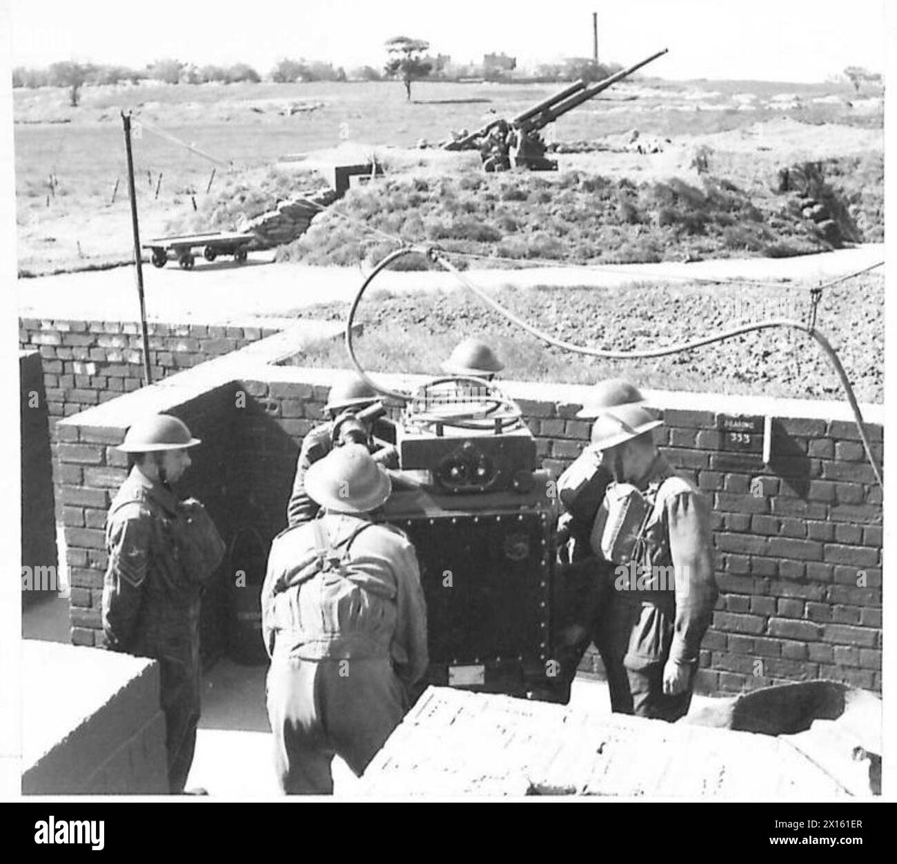 I cannonieri antiaerei esercitano utilizzando il dispositivo predittivo, con un cannone posizionato dietro, simulando le condizioni operative per colpire gli aeromobili. Foto Stock