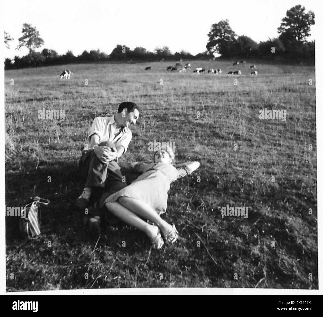 Due civili godono della campagna e del sole fuori da un villaggio francese durante le operazioni del 21st Army Group dell'esercito britannico. Foto Stock