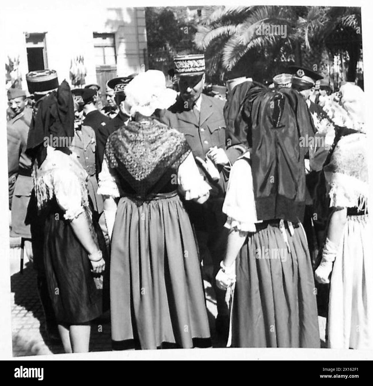 Dopo le parate, il generale Giraud incontra ragazze francesi vestite con costumi nazionali durante le operazioni dell'esercito britannico in Nord Africa, Sicilia, Italia, Balcani e Austria. Foto Stock