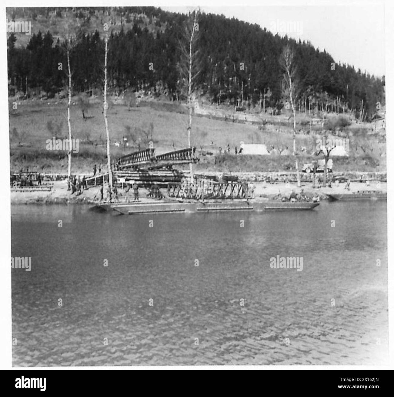 Il primo molo è preparato per la campata del ponte Bailey, posizionata per essere spinta sui rulli attraverso il fiume po sotto la supervisione dell'esercito britannico. Foto Stock