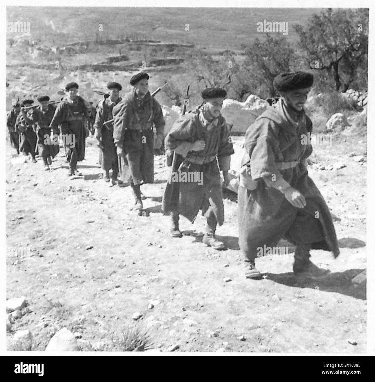 I Goum della Quinta Armata in Italia sono mostrati camminare su un sentiero roccioso per partecipare a una cerimonia in onore dei soldati britannici deceduti. Foto Stock