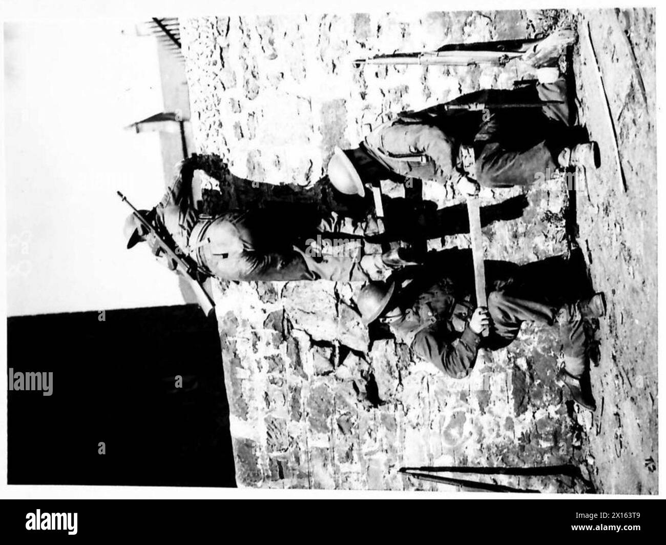 Una squadra dimostrativa ha superato un alto muro utilizzando gradini di legno come parte dell'addestramento di combattimento di strada, British Army. Foto Stock