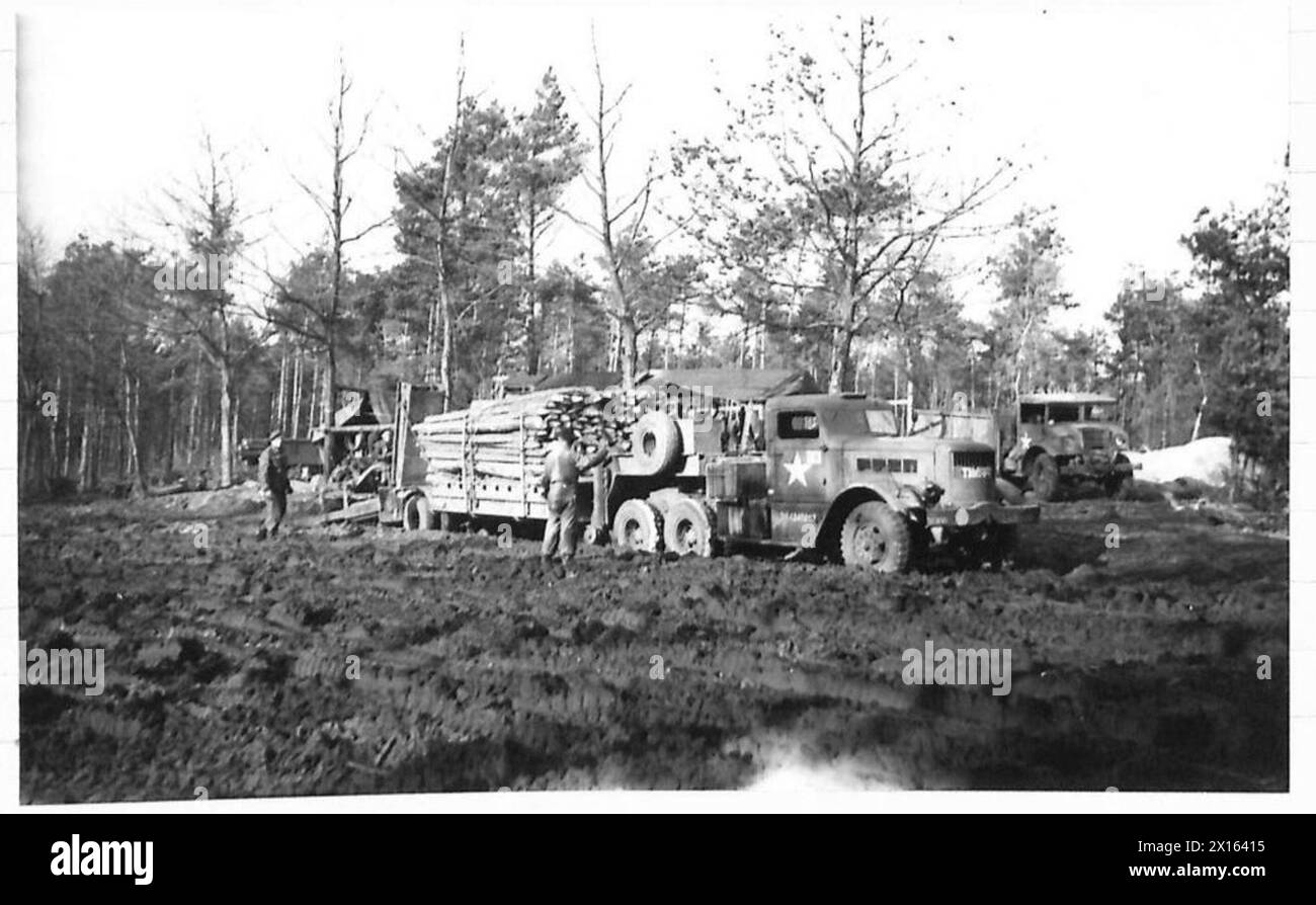 In Olanda, un carro armato carico di tronchi tagliati viene spostato dal fango in una zona di carico da un bulldozer, British Army, 21st Army Group. Foto Stock