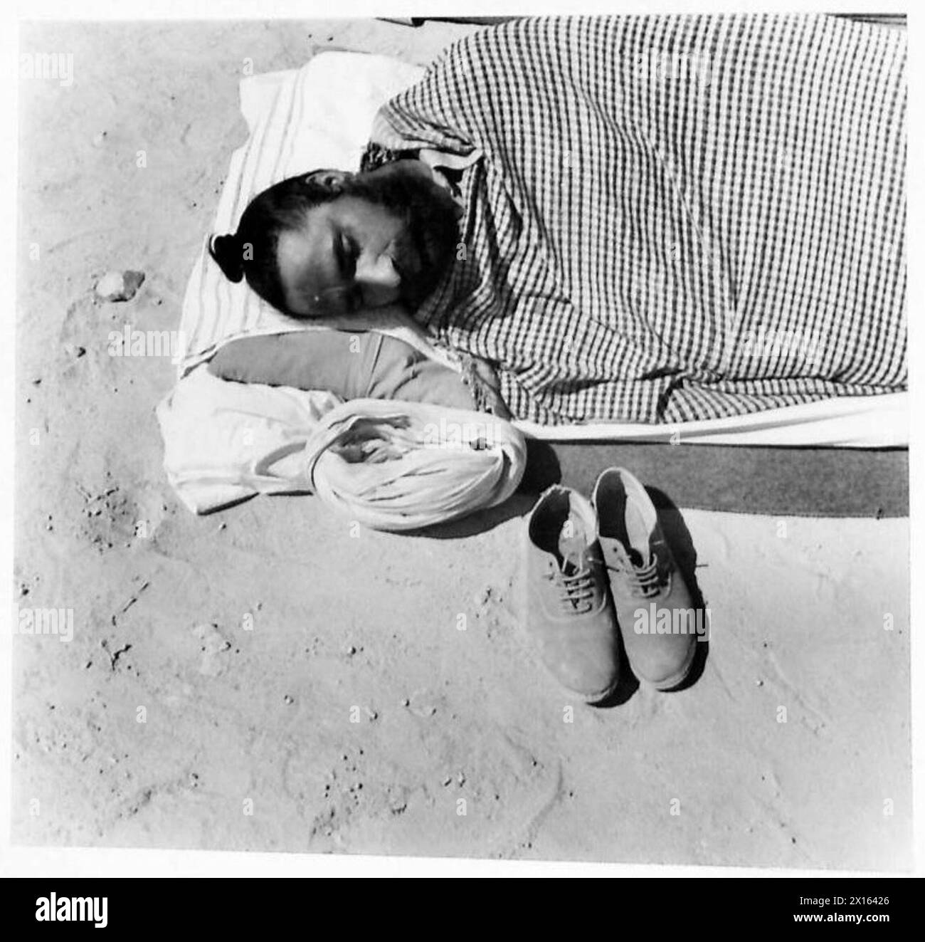I soldati sikh dormono nell'aperto deserto occidentale con i capelli arrotolati in una piccola palla sulla testa, British Army. Foto Stock