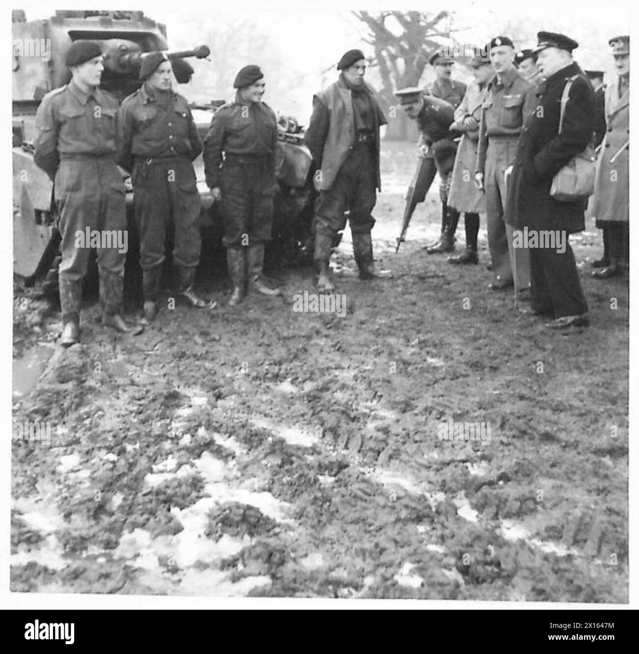 Il primo Ministro parla con un equipaggio di carri armati durante una visita al suo ex battaglione, notando le condizioni fangose. Foto Stock