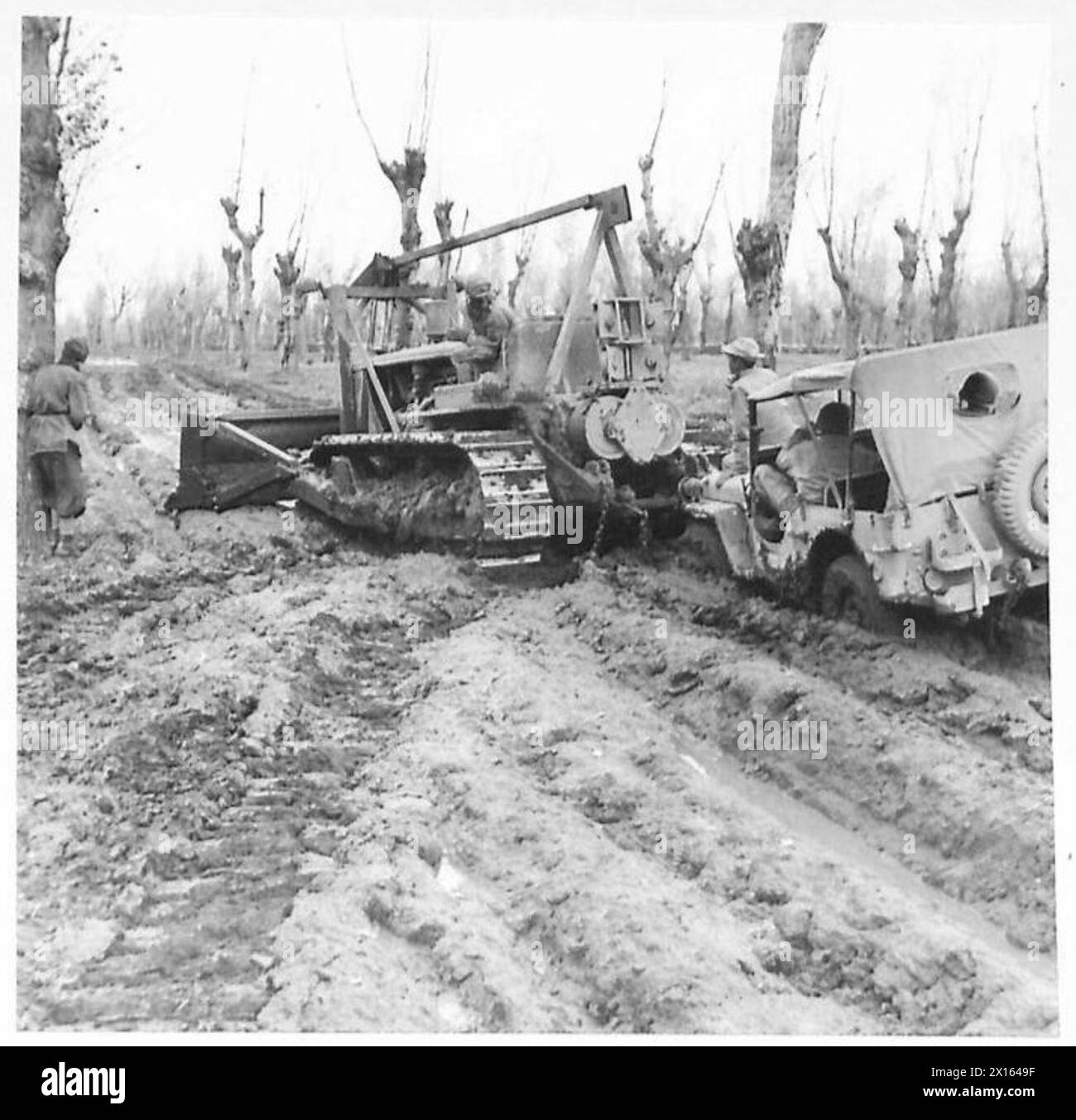 ITALIA: QUINTO ESERCITO (VARIE) - un trattore caterpillar americano tenta di spostare parte del fango da una corsia della Fifth Army Sector British Army Foto Stock