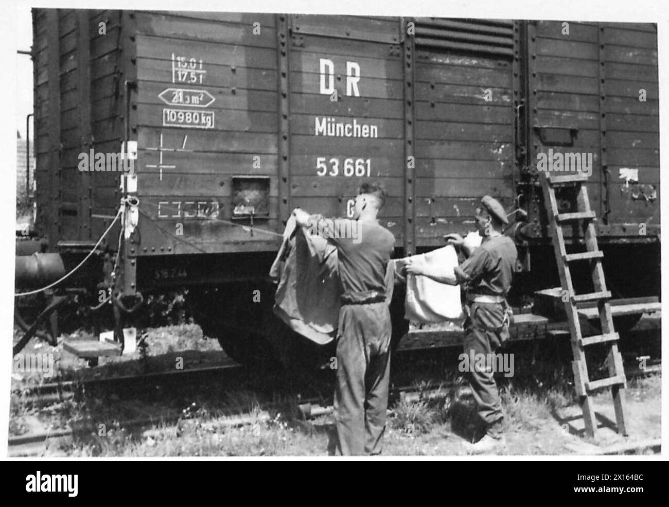 Sapper G.W. Waterton e Private Lumsden, polizia militare dell'esercito britannico del 21st Army Group, passano il bucato alla stazione di Bayeux su un furgone ferroviario della Deutsche Reichsbahn. Foto Stock