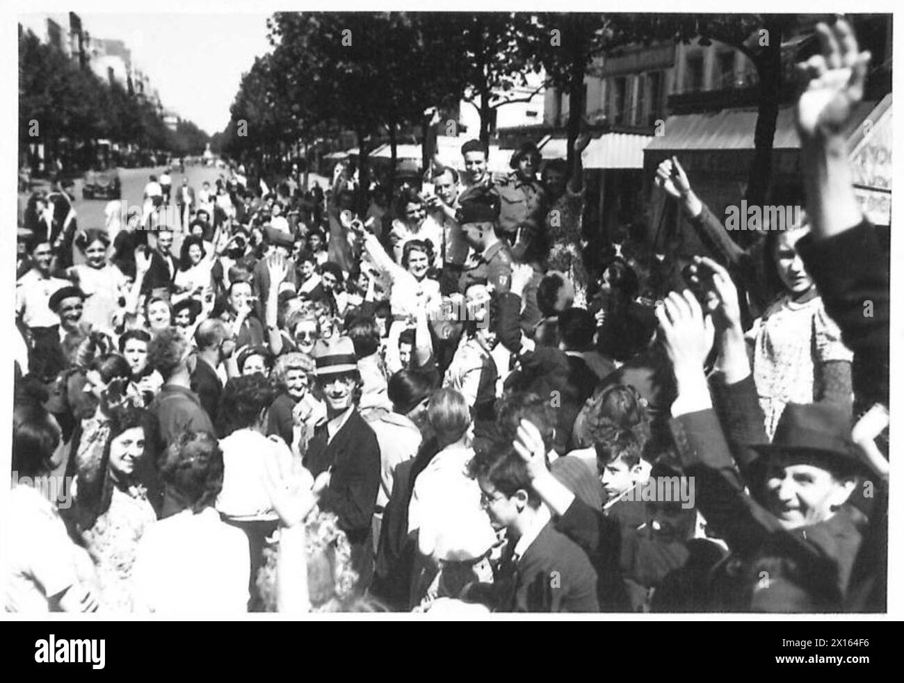 Folle di parigini si riunirono per le strade per dare il benvenuto alle truppe britanniche, americane, canadesi e francesi che entravano nella città liberata di Parigi, celebrando la fine dell'occupazione e l'arrivo delle forze alleate. Foto Stock