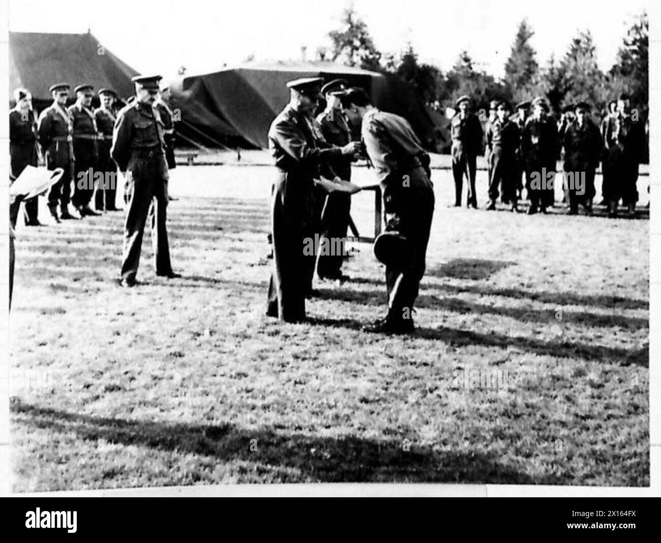 Il Brigadiere R.F.K. Belchem riceve il C.B.E. sul campo, riflettendo gli onori militari cerimoniali e il riconoscimento del servizio da parte dell'esercito britannico. Foto Stock