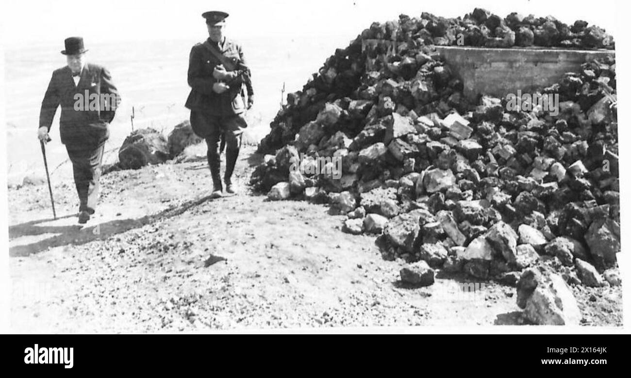 Winston Churchill è visto camminare lungo la costa durante il suo tour ufficiale nel Nord-est, osservato dal personale dell'esercito britannico. Foto Stock