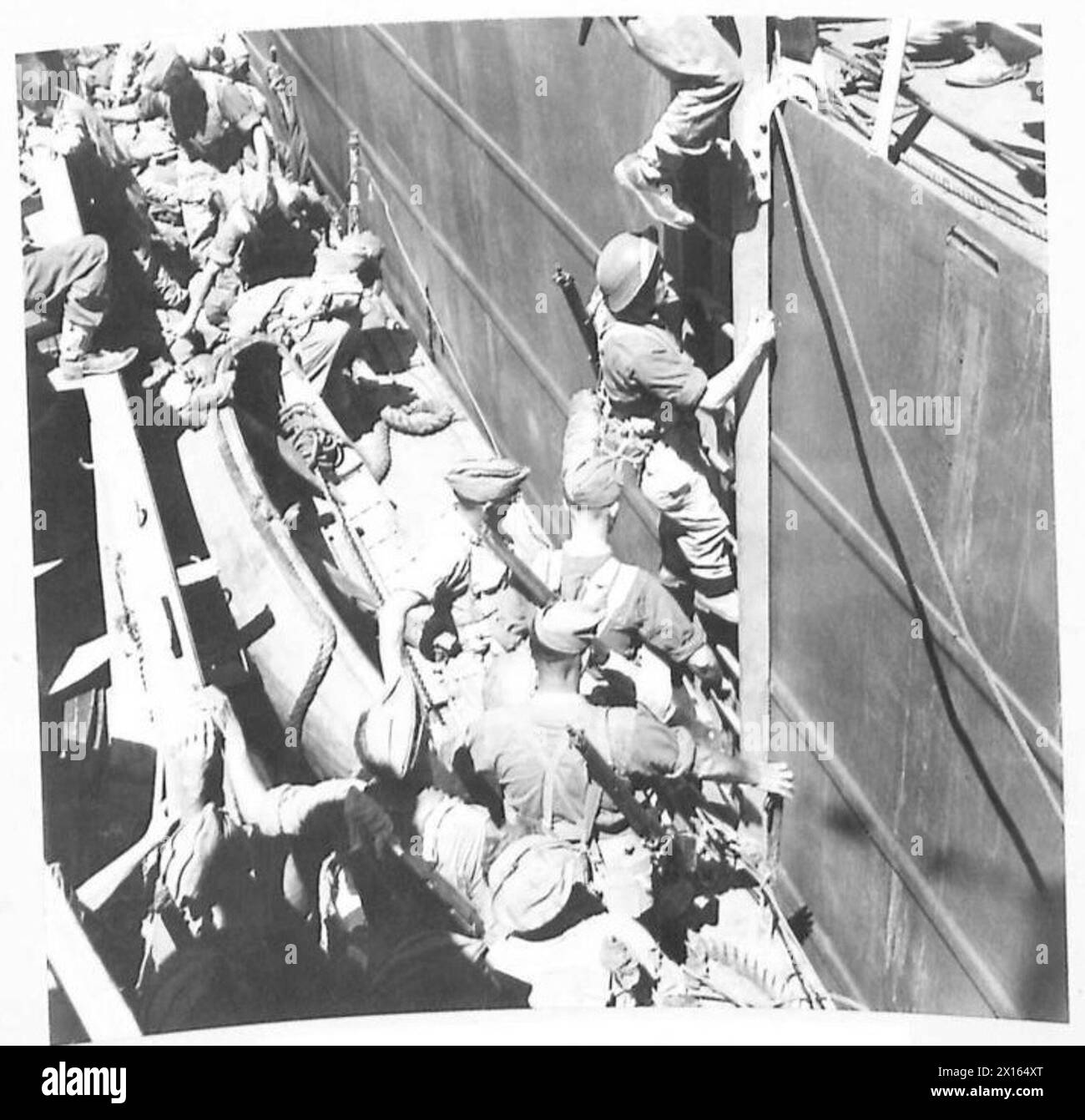 Le truppe salgono a bordo di una nave da sbarco Tank (LST) da una Landing Craft Infantry (LCI) a metà del corso d'acqua durante i preparativi per l'invasione del Nord Africa. Foto Stock