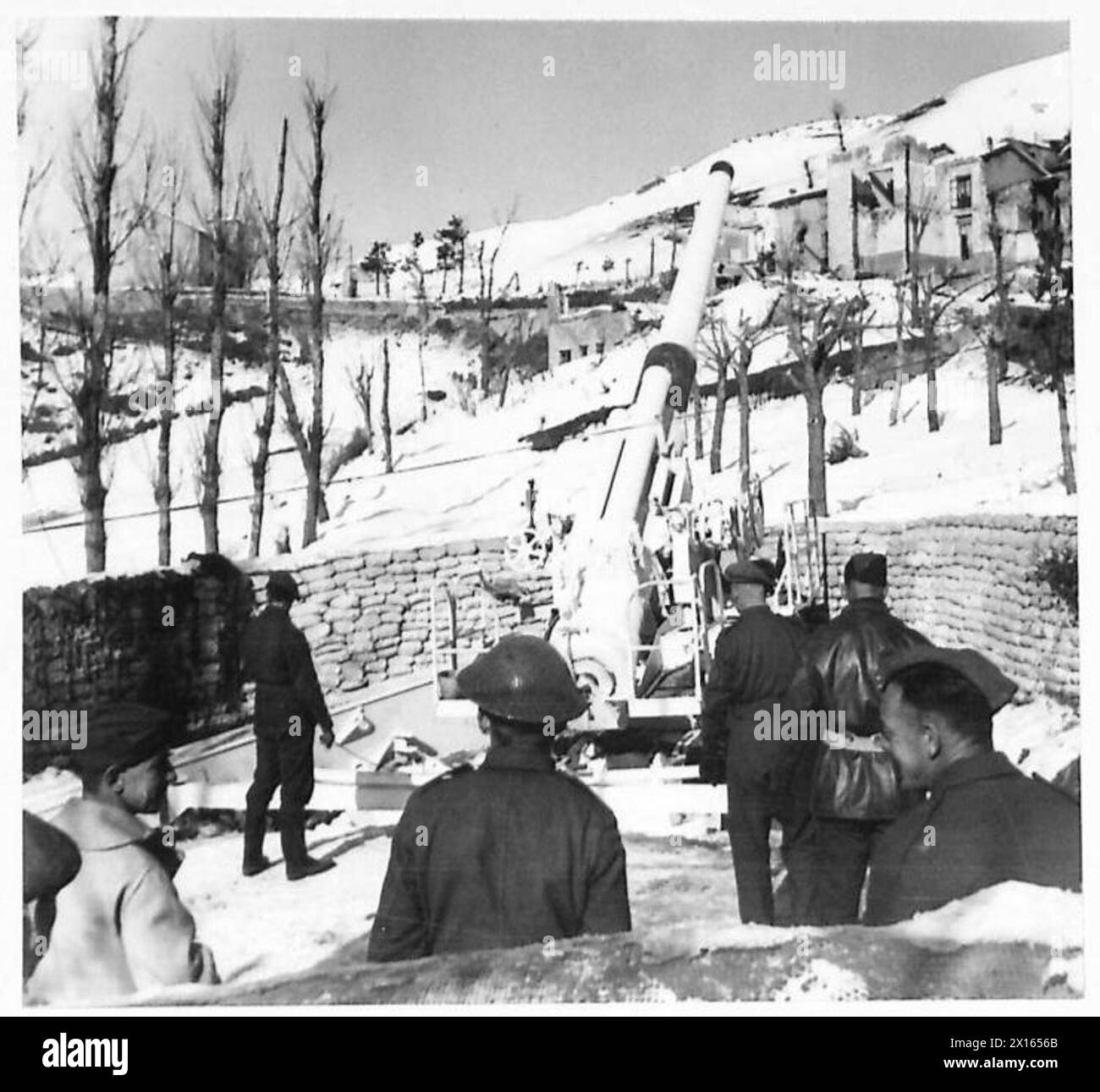 Un cannone inglese da 8 pollici, mimetizzato con vernice bianca, è pronto a sparare con un cannone che tiene il cordone durante le operazioni in condizioni di neve a supporto della 5th Army alleata. Foto Stock