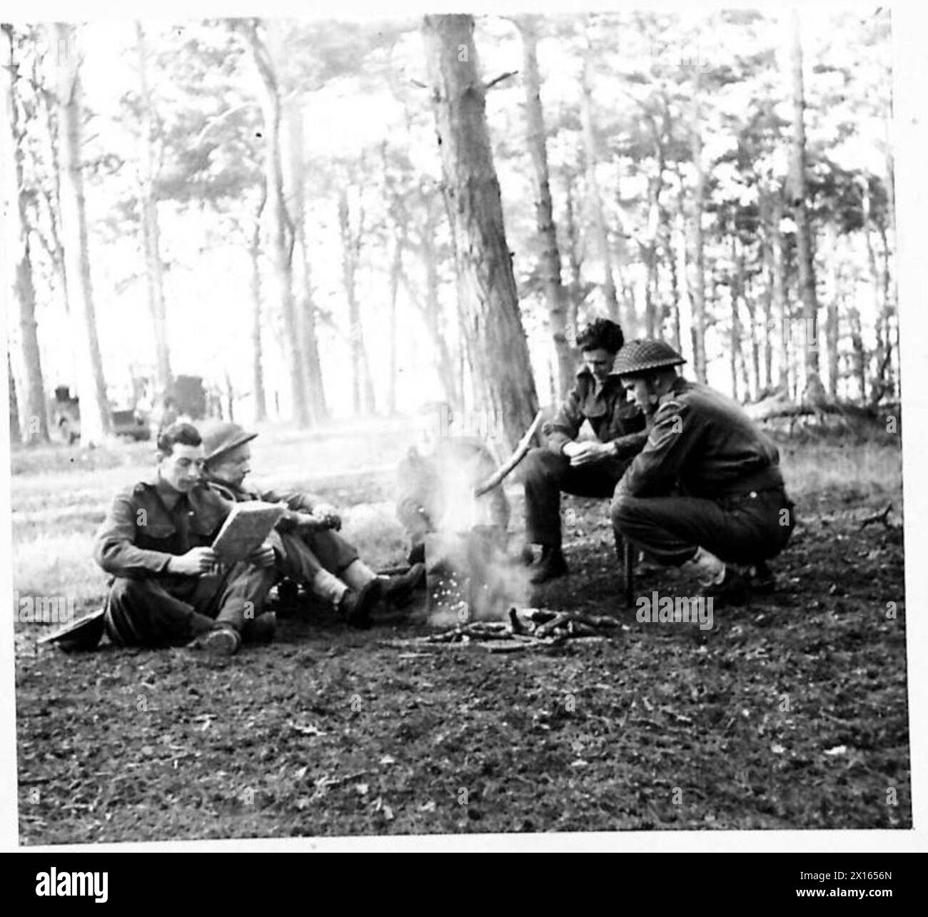 L'autista T. Allison e altri conducenti si siedono intorno a un incendio all'aperto, leggendo giornali, pronti per l'immediato dispiegamento da parte dell'esercito britannico. Foto Stock