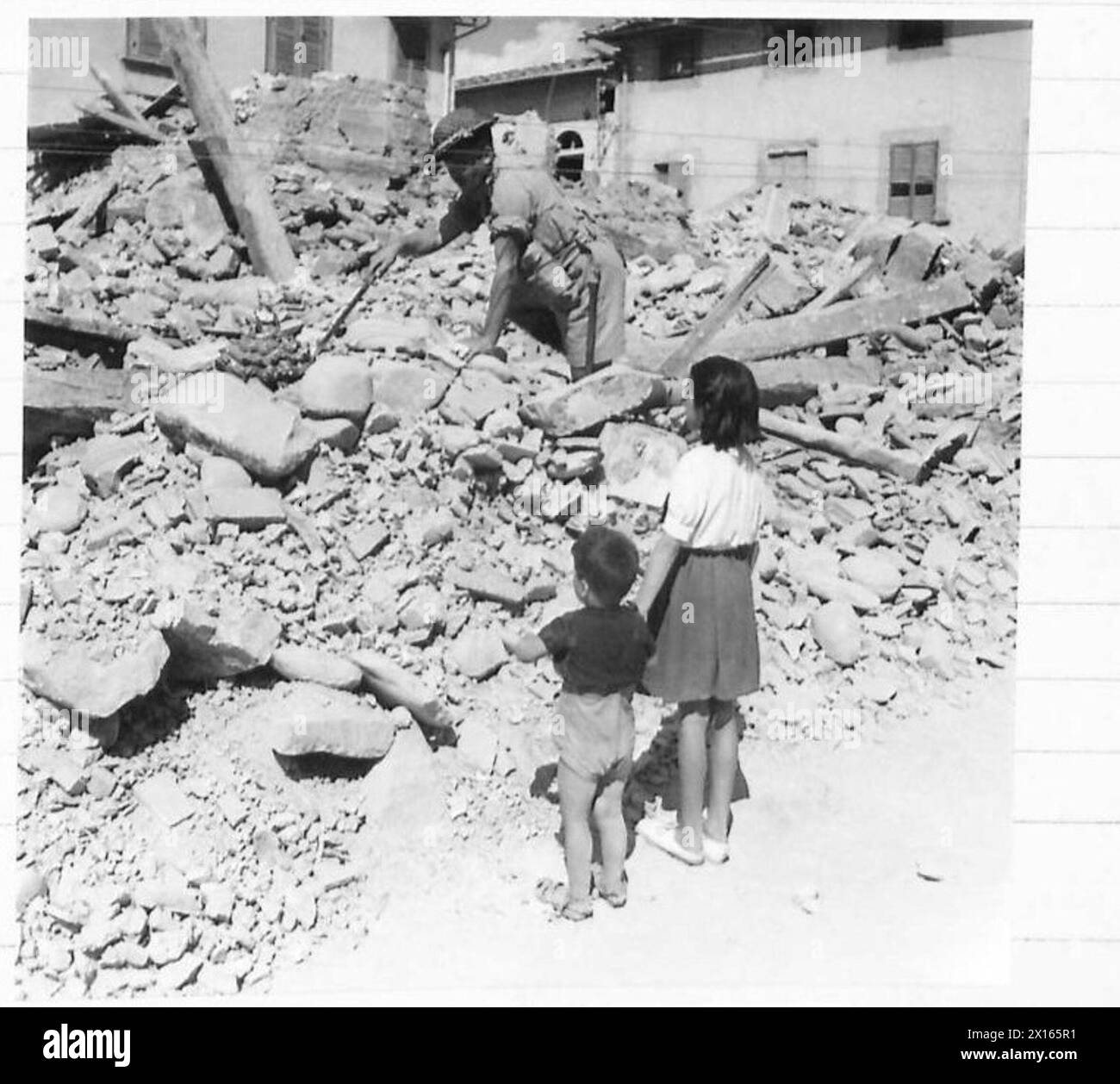 I Royal Engineers dell'Eighth Army esaminano con cautela una bambola nelle rovine di Faella durante un'operazione di sminamento in cui morirono tre uomini, evidenziando i pericoli post-combattimento. Foto Stock