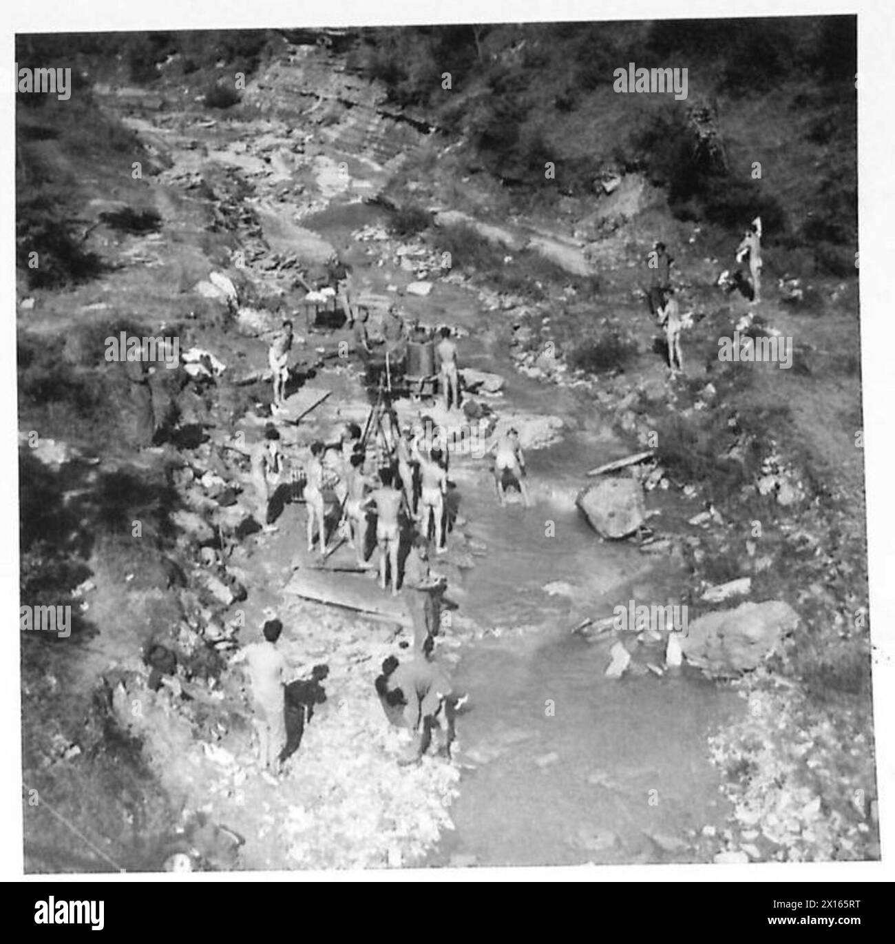 Gli uomini dei 16/5 Lancieri usano le unità da bagno in prima linea per pulire il fango accumulato durante una pausa in tempo, sotto il rischio di fuoco nemico in Italia. Foto Stock