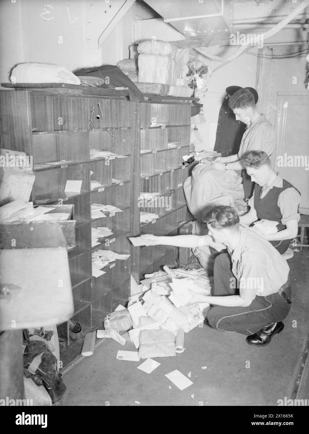Nel 1940, a bordo della HMS Rodney, vengono mostrati tre Marines che ordinano 700 lettere e pacchi nell'ufficio postale della nave. Foto Stock
