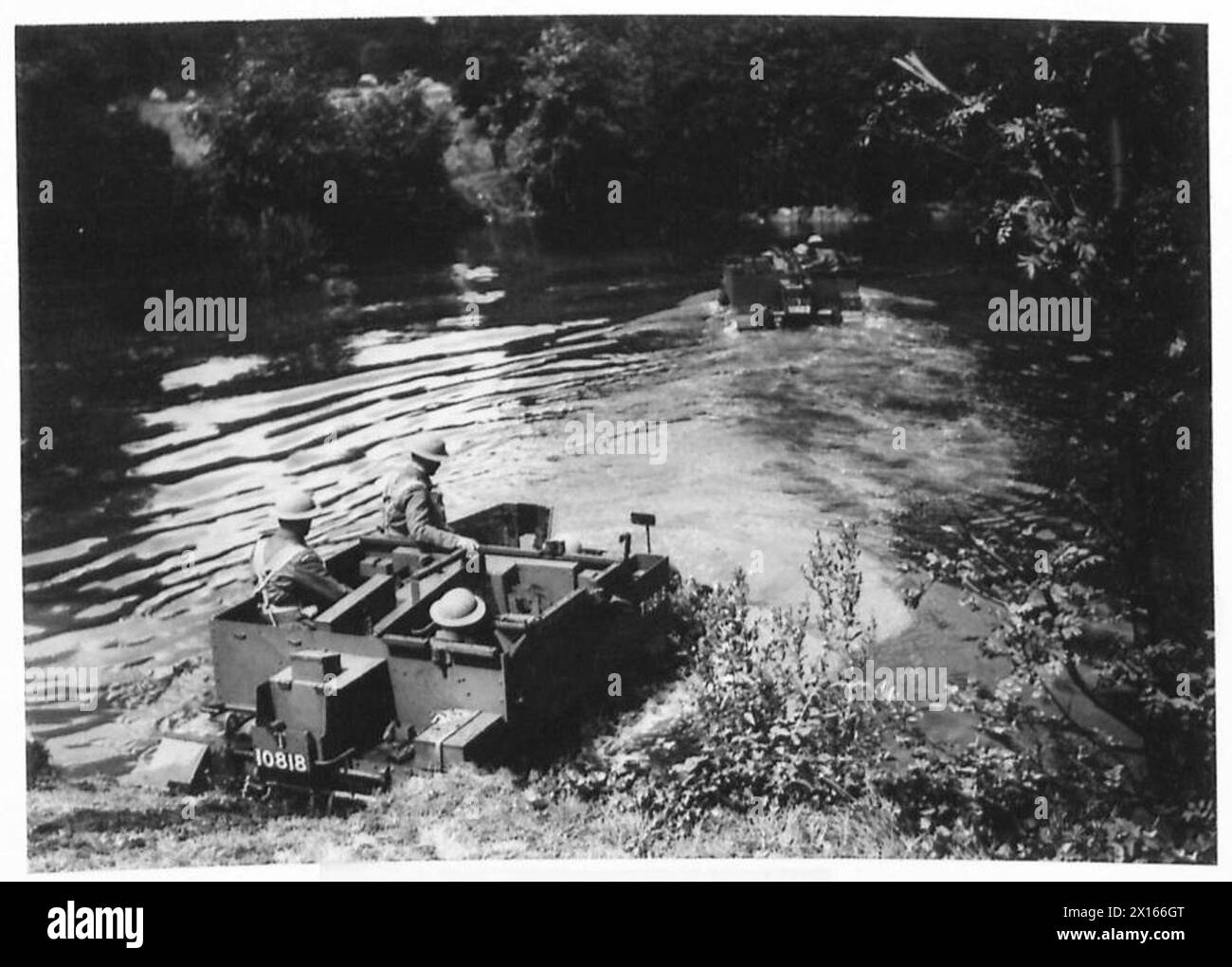 Sua Maestà il Re visita le guardie gallesi mentre le portaerei Bren attraversano un corso d'acqua durante le operazioni militari. Foto Stock