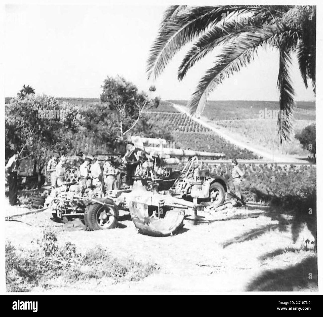 I corrispondenti di guerra alleati ispezionano le attrezzature nemiche catturate, tra cui il versatile cannone da 88 mm, per rendiconti e valutazioni militari. Foto Stock