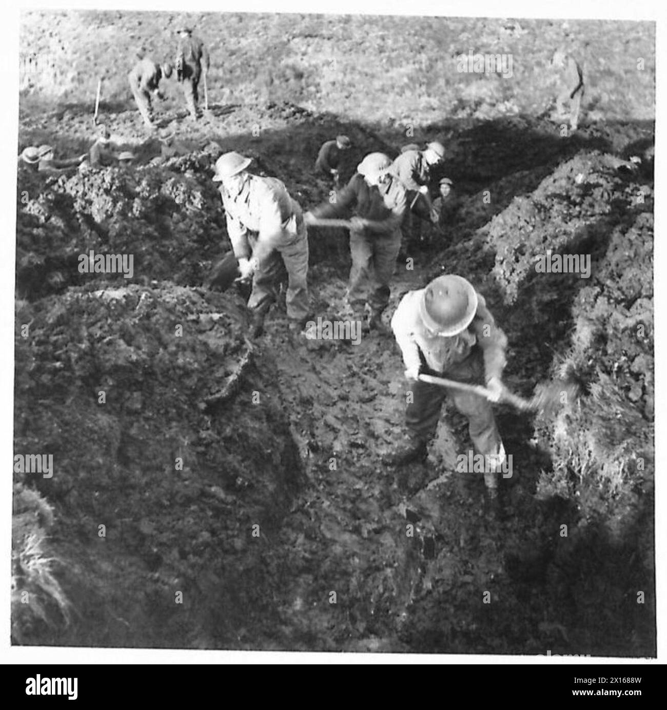 I sappers rimuovono la terra sciolta dal drenaggio e la depositano sul bankside mentre costruiscono una nuova strada attraverso Sperrins, Irlanda del Nord. Foto Stock