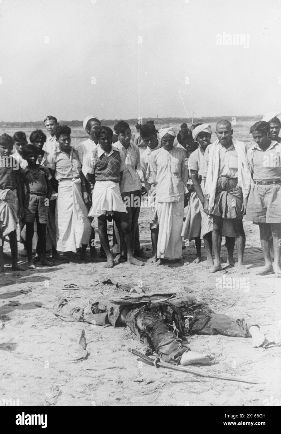 IL GRUPPO DI VOLONTARI AMERICANI - gli abitanti del villaggio birmano raggruppano attorno al corpo di un pilota giapponese abbattuto dall'AVG su Rangoon, 1942 Foto Stock