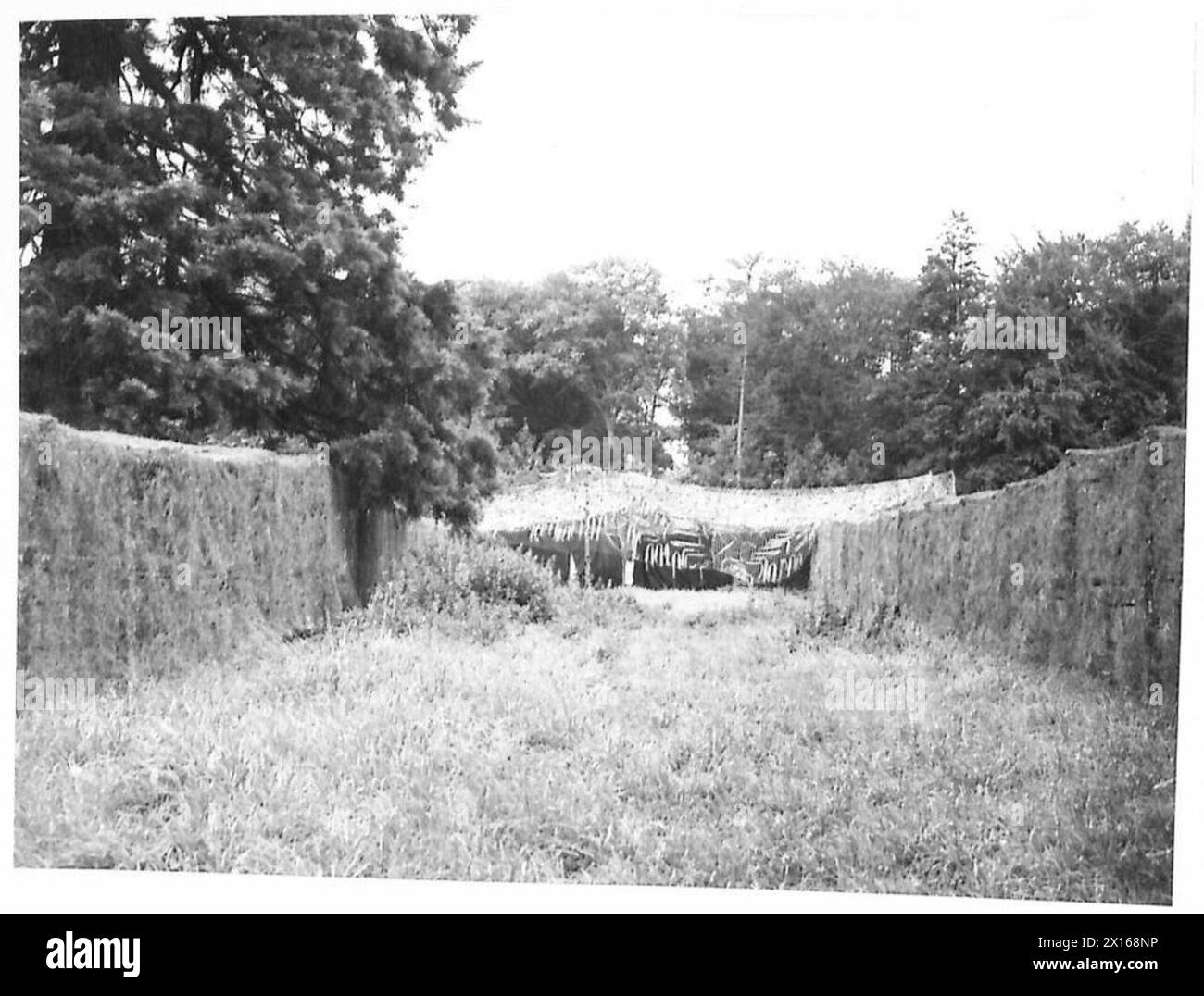 Le scatole di benzina sono impilate e mimetizzate con lana di filo verde e teloni in un deposito militare, per un totale di 15.720 barattoli. Foto Stock