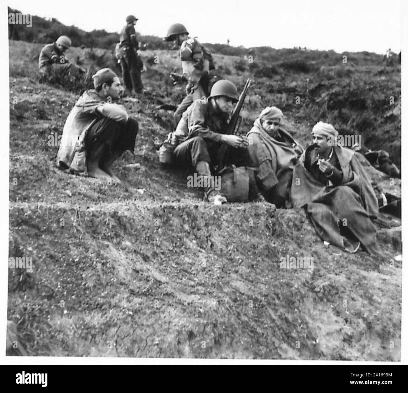 Un soldato americano della 34th Infantry Division degli Stati Uniti parla con gli arabi locali in attesa di muoversi nell'entroterra dopo essere sbarcato a Surcouf Beach, 20 miglia ad est di Algeri, 9 novembre 1942, operazione Torch. Foto Stock