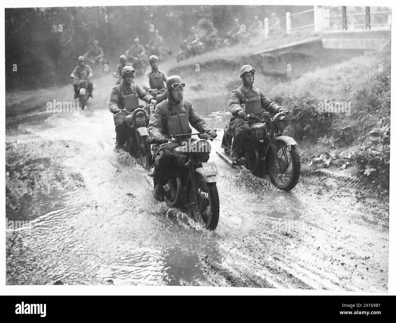 I motociclisti dell'esercito britannico attraversano una spruzzata d'acqua durante gli esercizi di addestramento, dimostrando abilità di manovrabilità e manovrabilità, British Army. Foto Stock
