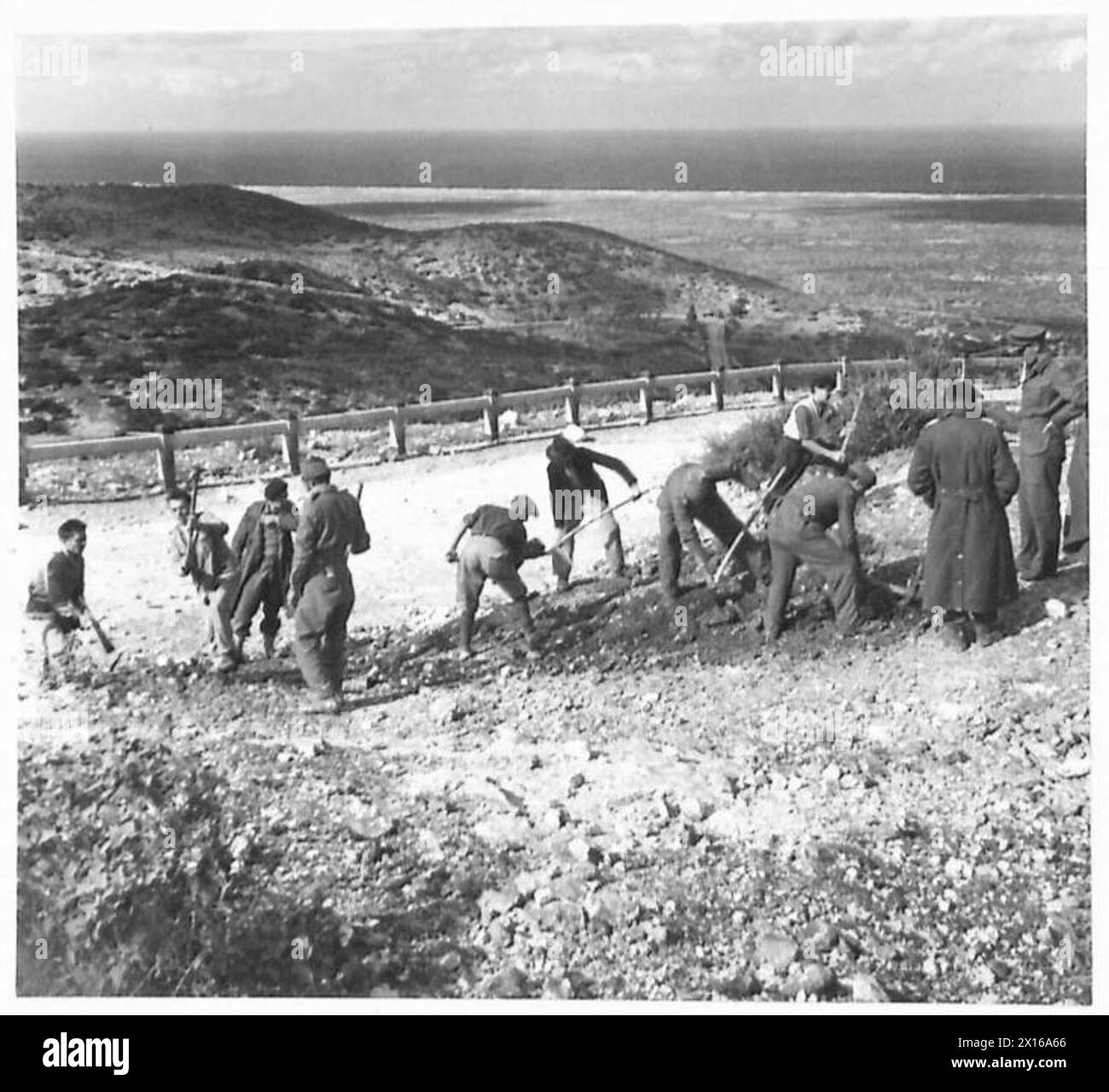 FOTO SCATTATE INTORNO A BARCE - gli abitanti locali hanno aiutato molto facilmente i British Sappers (RES) a fare una deviazione intorno a un pezzo di strada mal soffiato a 16 miglia ad ovest di Barce. La maggior parte della popolazione locale è costituita da coloni italiani. Le immagini mostrano che stanno lavorando duramente sul nuovo by-pass, dove si unisce alla strada principale dell'esercito britannico Foto Stock