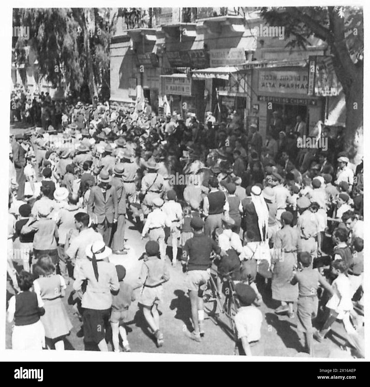 Durante la campagna di reclutamento neozelandese a Gerusalemme, folle di bambini e adulti seguono una banda in marcia per le strade. Foto Stock