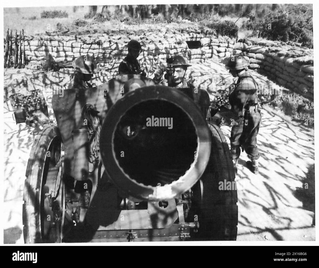 I soldati esaminano la canna di un'arma preparata per l'uso contro le precedenti forze nemiche Foto Stock