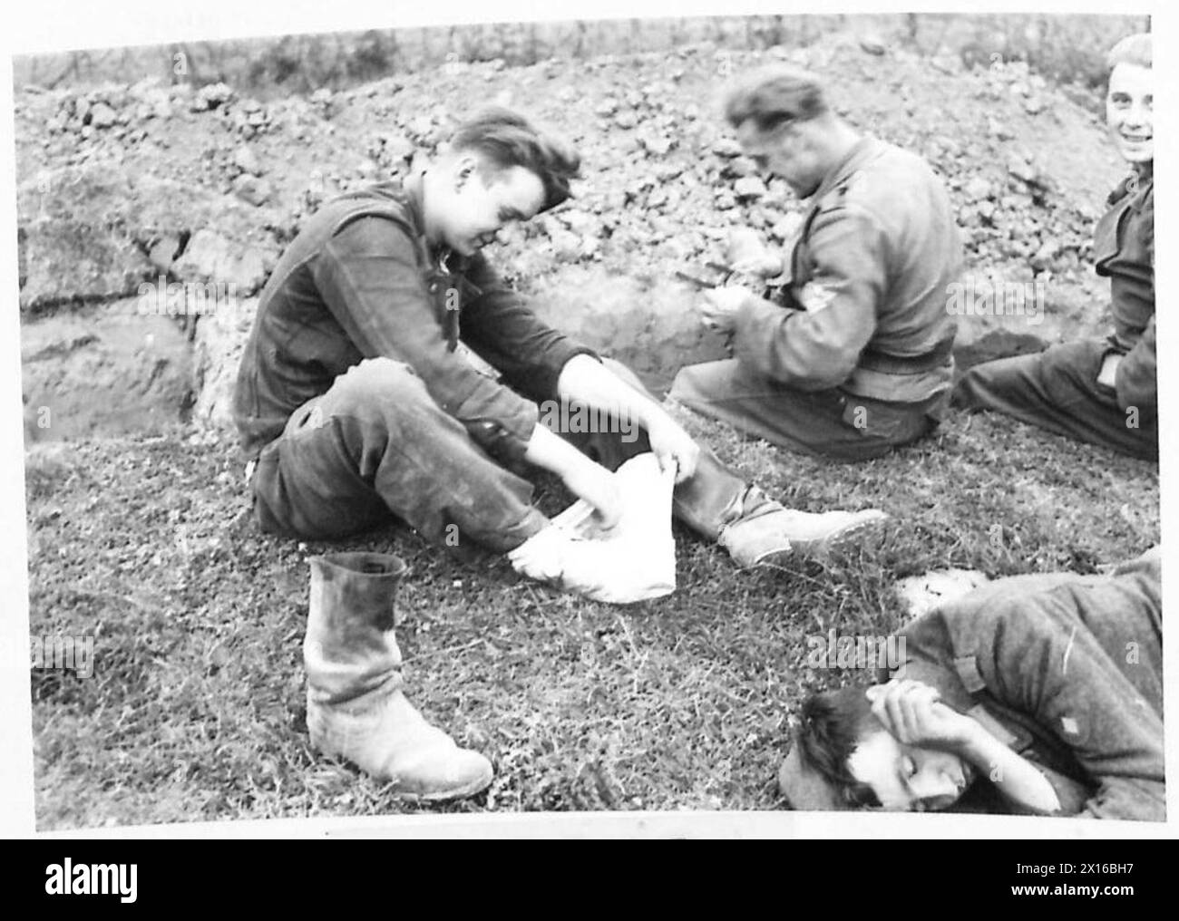 Un prigioniero tedesco catturato si lega i piedi con un panno, notando che raramente aveva rimosso gli stivali dal 6 giugno sotto la supervisione del 21st Army Group. Foto Stock