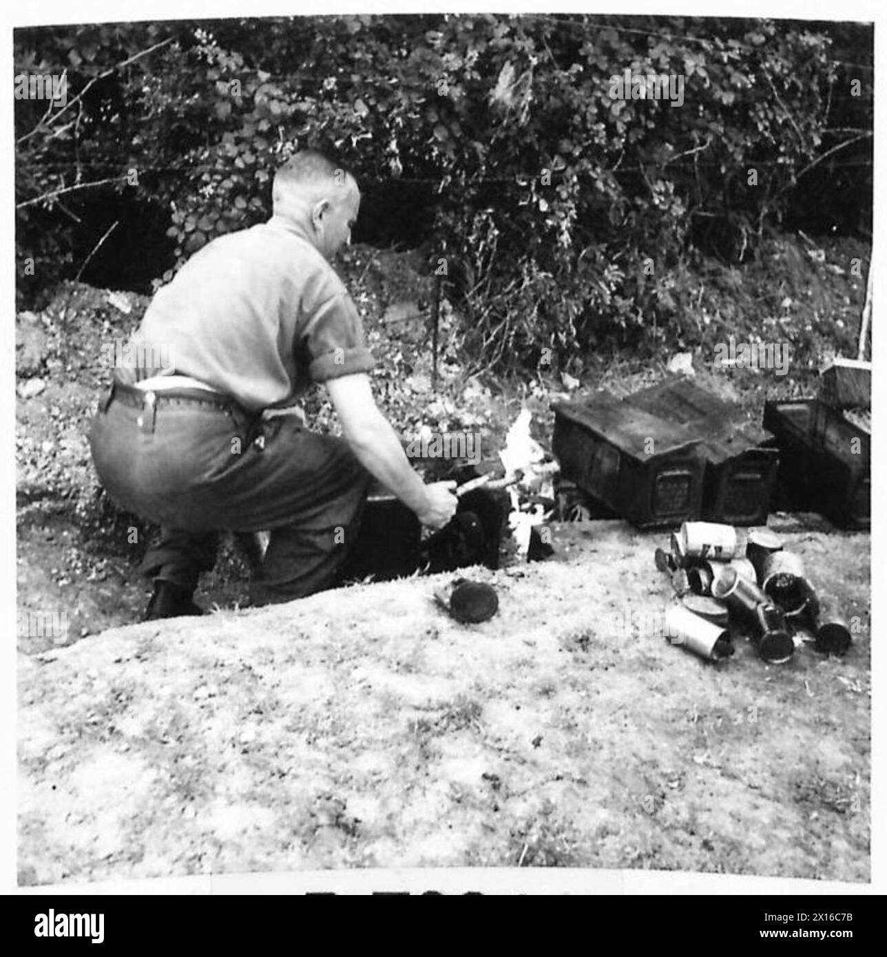 Il privato McCleary della sezione 10 Field Hygiene in Normandia brucia giornalmente le scatole di razione composte per prevenire le malattie, come precauzione sanitaria presa dall'esercito britannico, 21st Army Group. Foto Stock