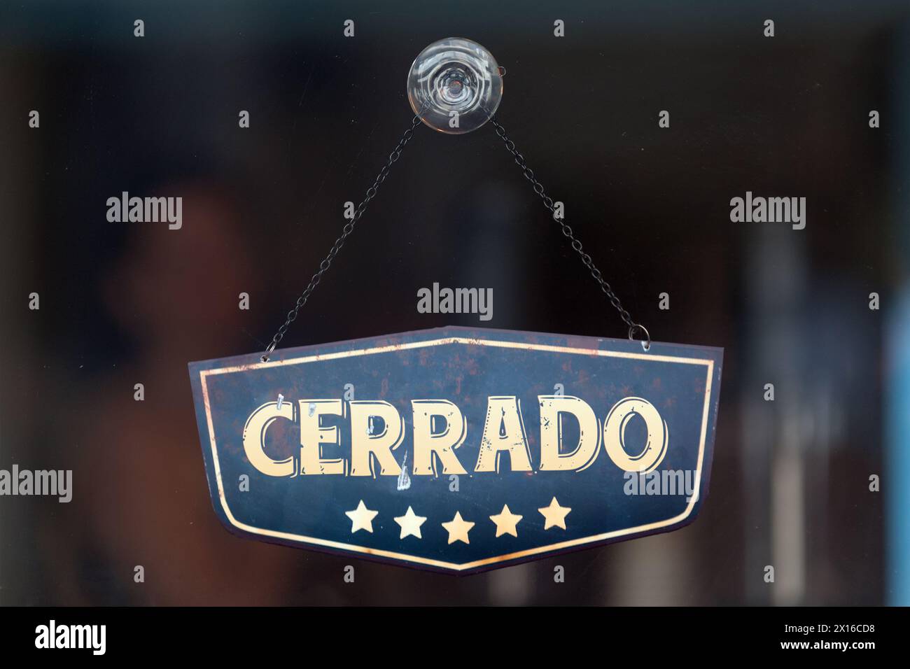 Un cartello vecchio stile nella vetrina di un negozio che recita in spagnolo "Cerrado", che in inglese significa "chiuso". Foto Stock