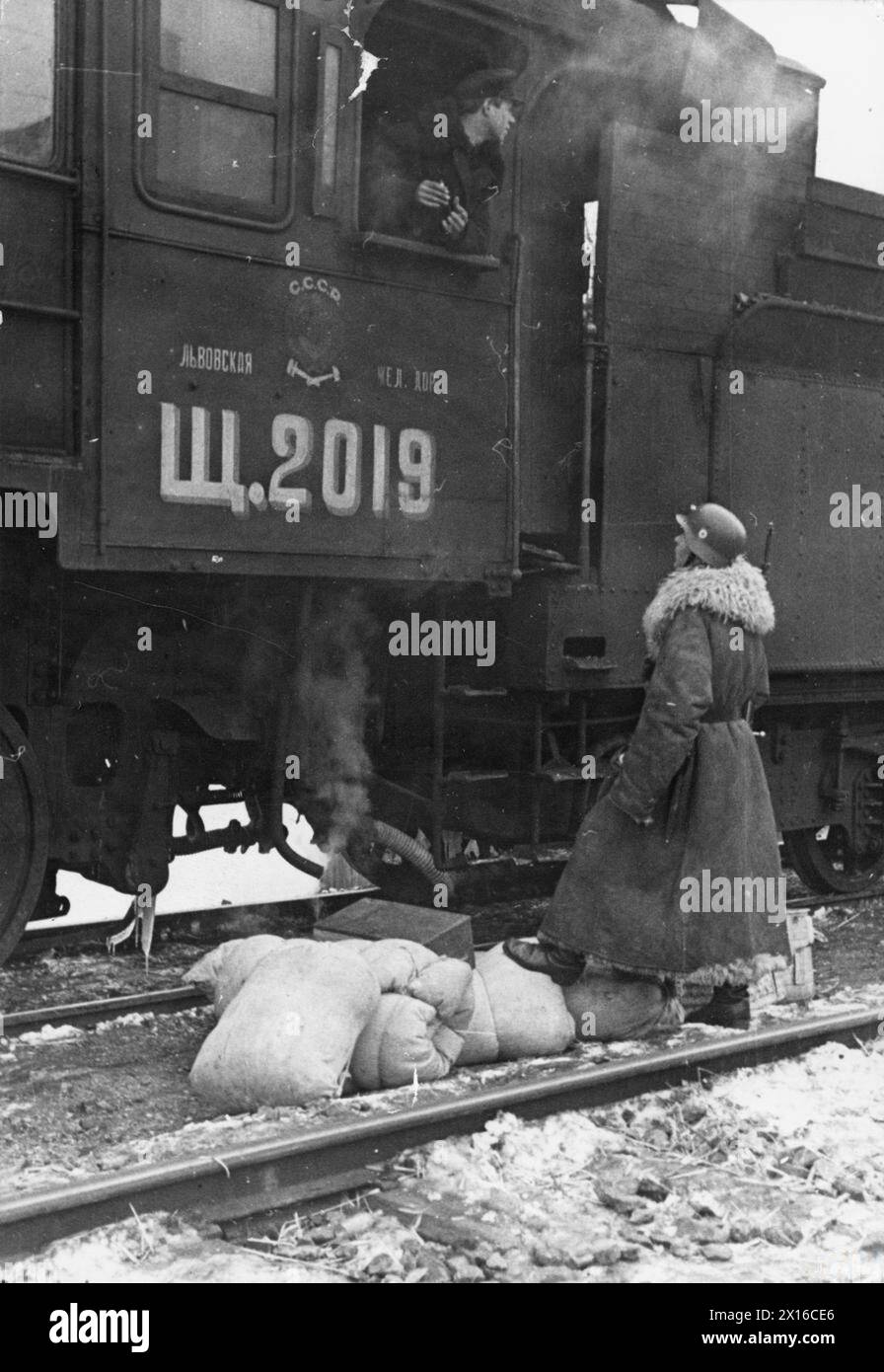 Un macchinista di locomotiva russo consegna petrolio alla Germania nazista ed è accolto da un poliziotto tedesco delle SS alla stazione di Przemyśl sul confine nazista-sovietico, gennaio-febbraio 1940. Foto Stock