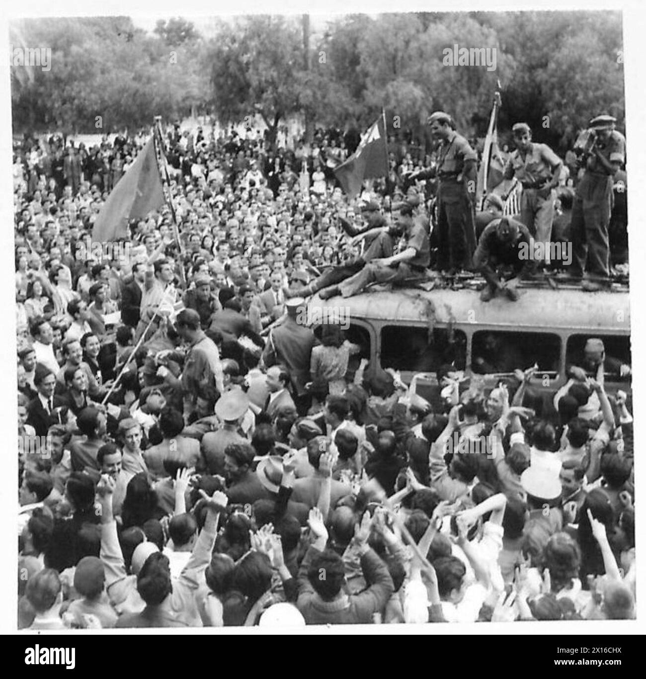 Un pullman che trasporta truppe britanniche entra ad Atene, accolto da una folla entusiasta. L'evento riflette la liberazione della città e l'accoglienza pubblica delle forze alleate durante la seconda guerra mondiale Foto Stock