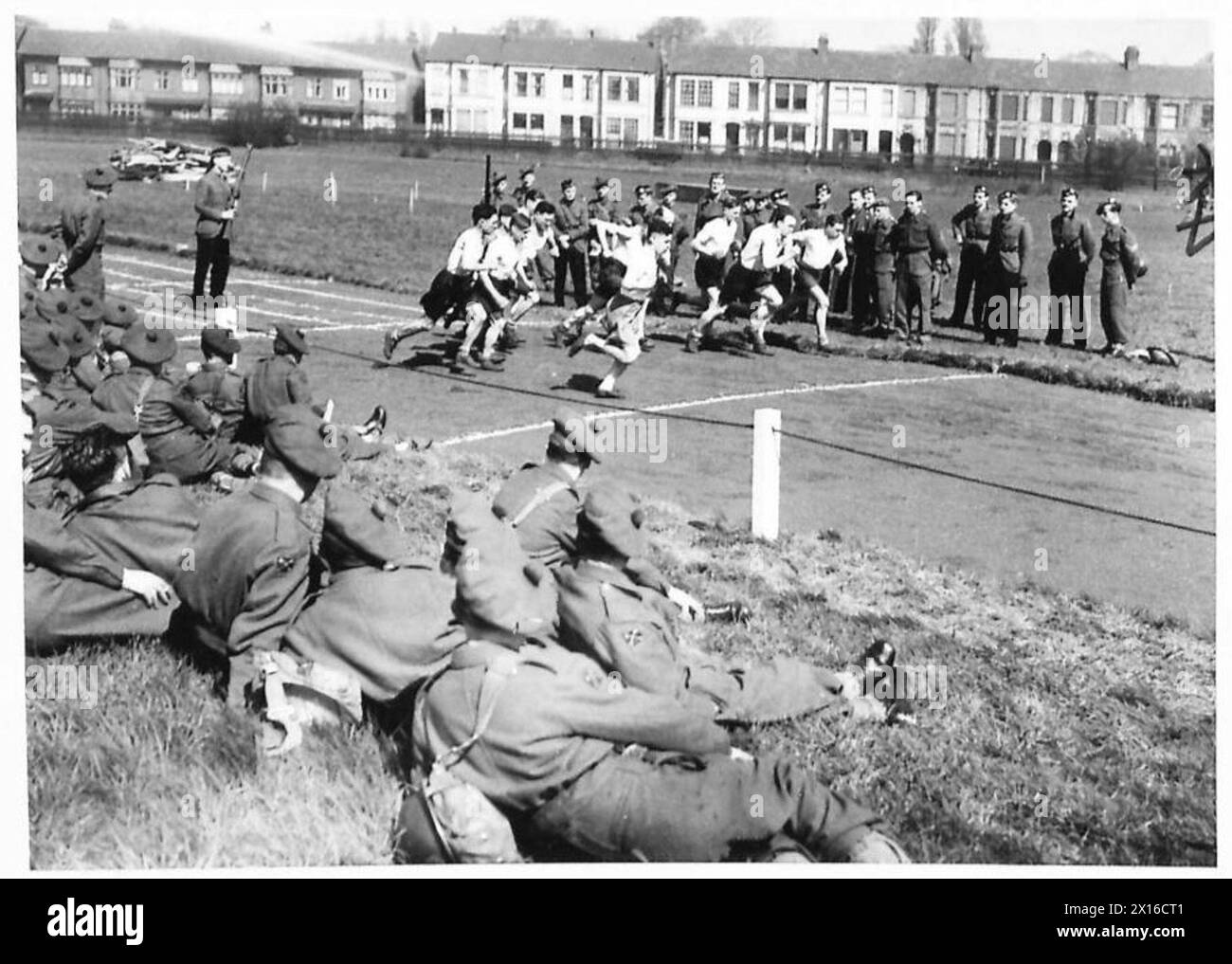 Una giornata di sport reggimentali prevede una corsa di un miglio, con soldati che partecipano e compagni che osservano, promuovendo il fitness fisico e il cameratismo all'interno del reggimento. Foto Stock