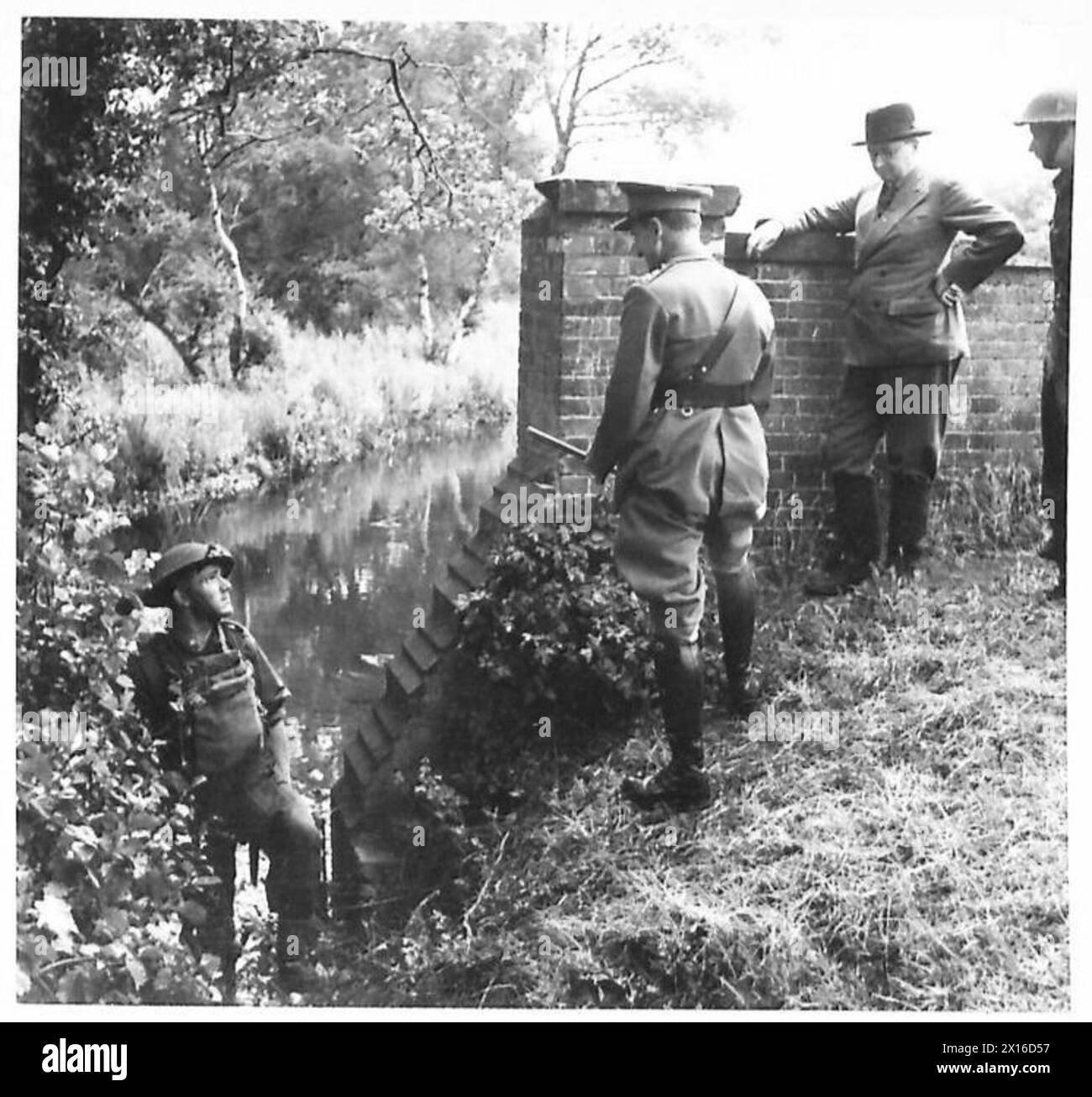 Durante un'esercitazione su larga scala nell'Eastern Command, il comandante in capo interroga un fanteria sul suo benessere mentre il Segretario di Stato per la Guerra osserva, documentato dall'esercito britannico. Foto Stock