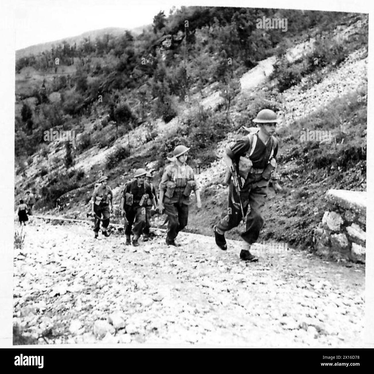 Un plotone di fanteria dell'esercito britannico inizia a salire su una ripida collina di 5.020 metri in un unico file lungo un sentiero roccioso in Italia. Foto Stock