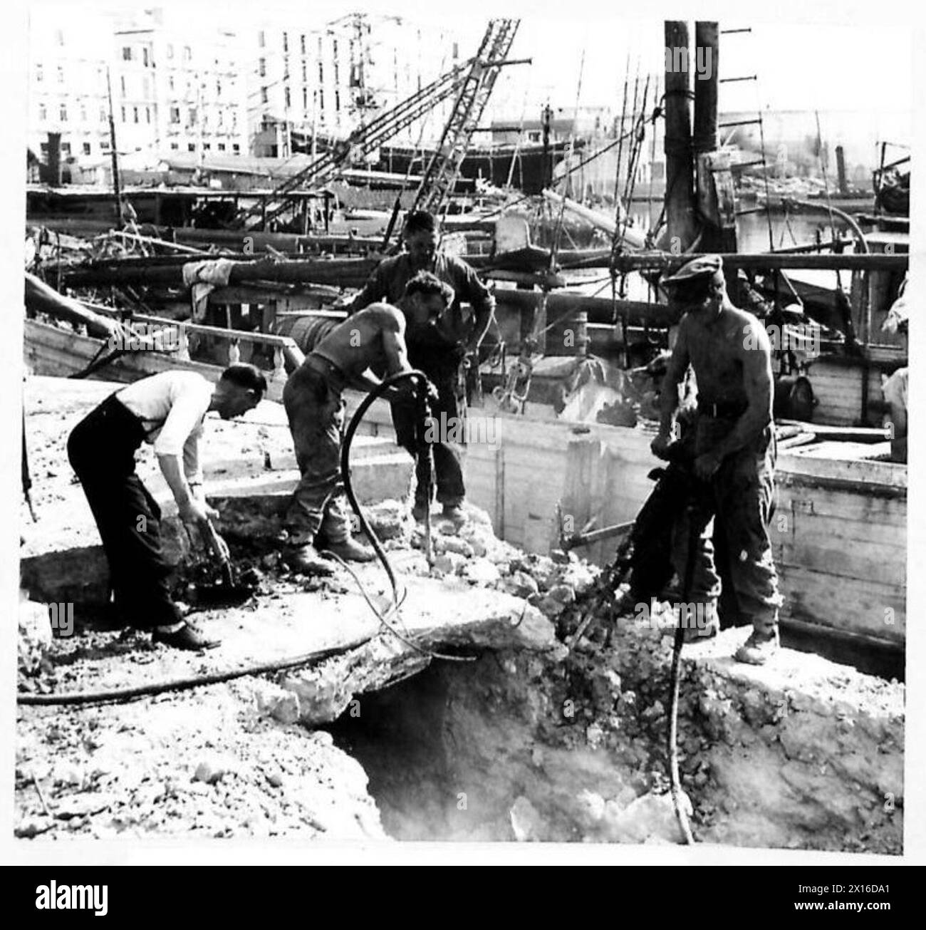 Durante l'invasione dell'Italia, i lavoratori locali assistono i Royal Engineers sulla banchina, sostenendo le operazioni logistiche e di costruzione dell'esercito britannico. Foto Stock