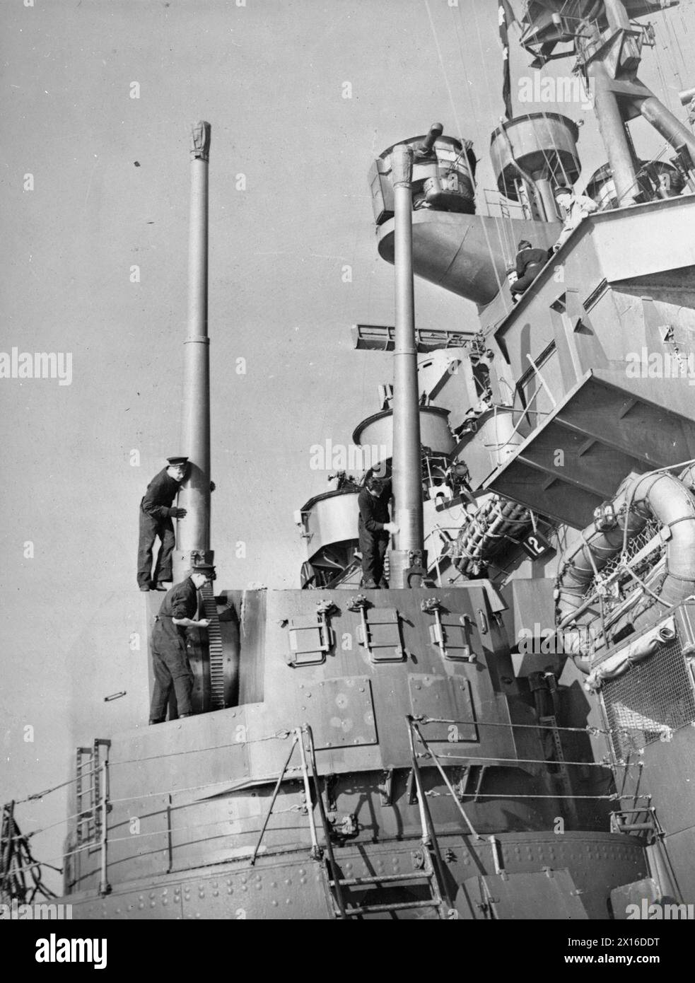 LA ROYAL NAVY DURANTE LA SECONDA GUERRA MONDIALE - uno degli otto attacchi gemelli Mark i per cannoni Mark i da 5,25 pollici Quick Fire (QF) Mark i viene pulito e oliato a bordo della HMS KING GEORGE V. la nave si trova in un porto britannico dopo il suo ritorno dagli Stati Uniti Royal Navy, RE GIORGIO V (HMS) Foto Stock